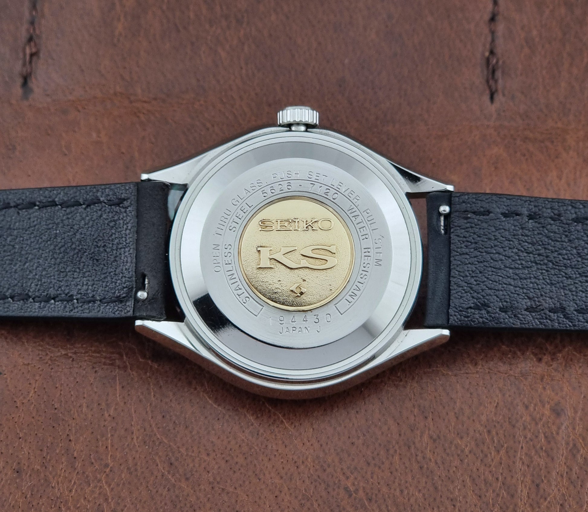 Vintage King Seiko Wristwatch 5626-7120 with black leather strap on a dark surface case back view