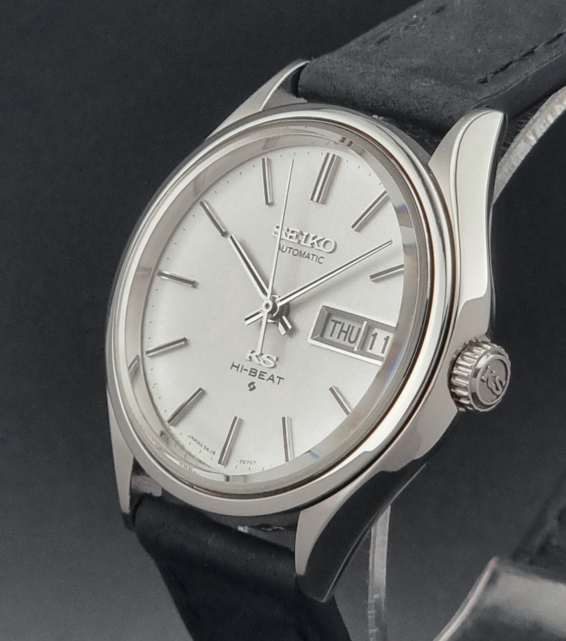 Vintage King Seiko Wristwatch Hi-beat 5626-7120 with a black strap on a dark background crown side profile