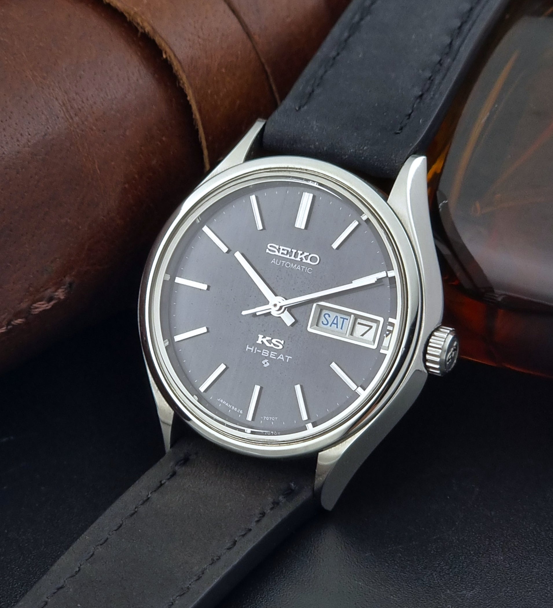 Vintage King Seiko Wristwatch 5626-7120 with black leather strap on a dark surface crown view