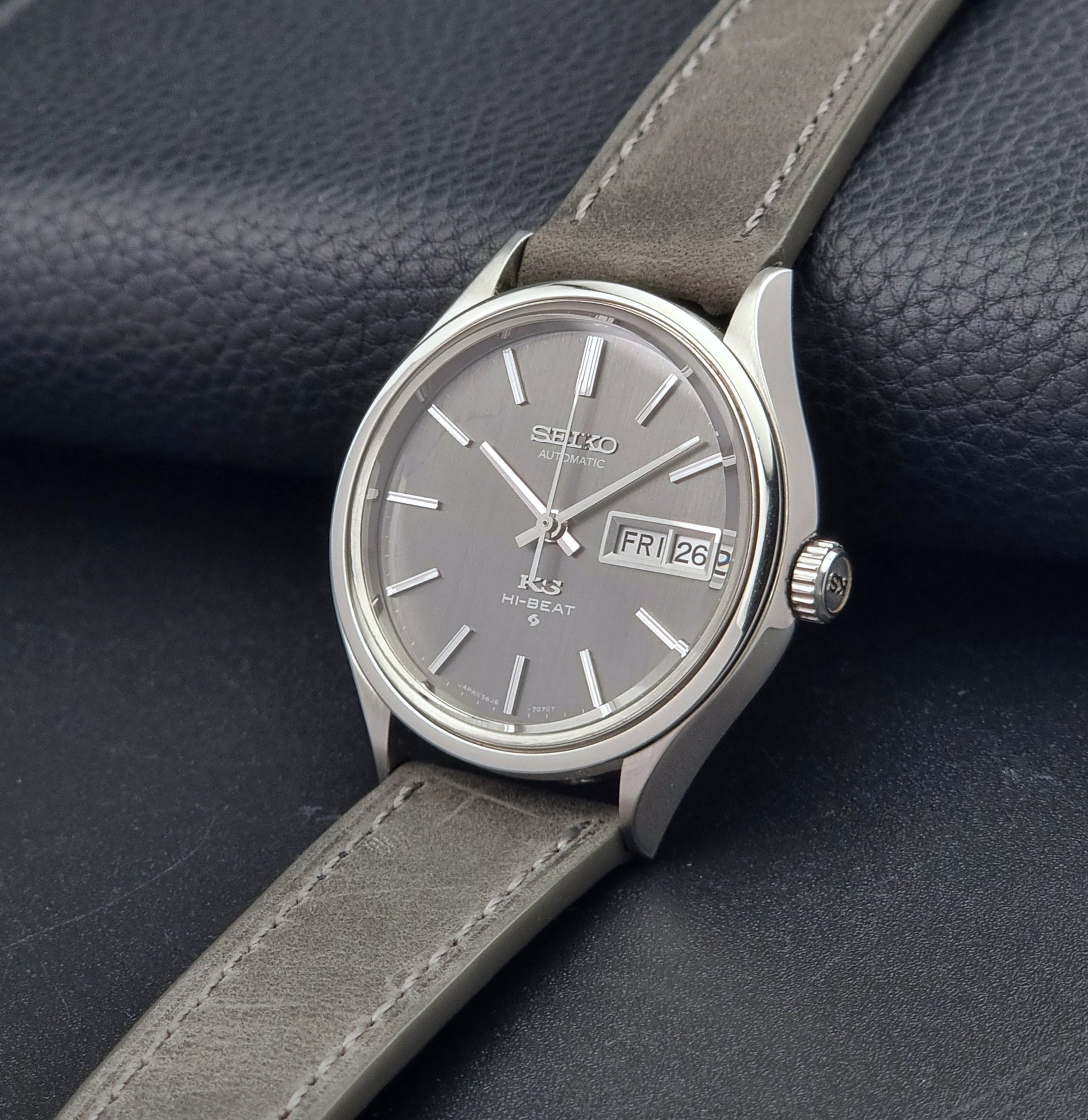 Vintage King Seiko watch with gray strap on a dark textured background