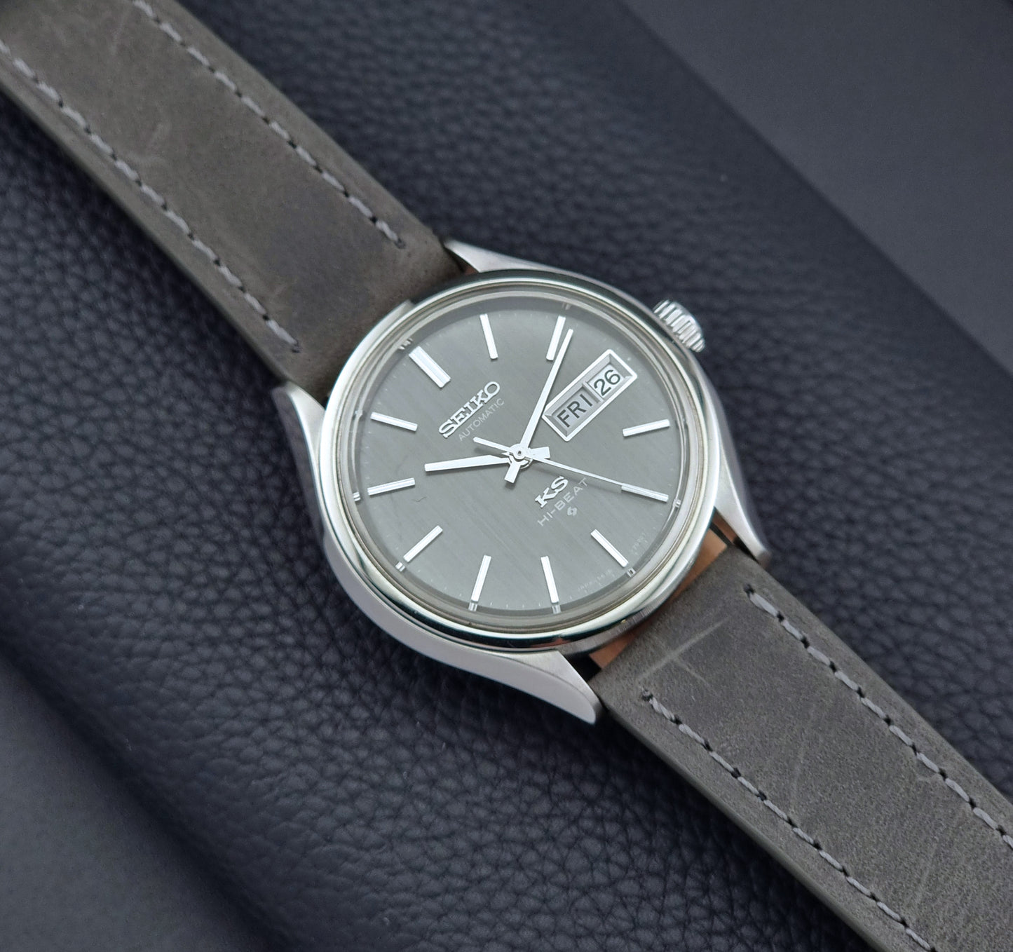Vintage King Seiko watch with gray strap on a dark textured background