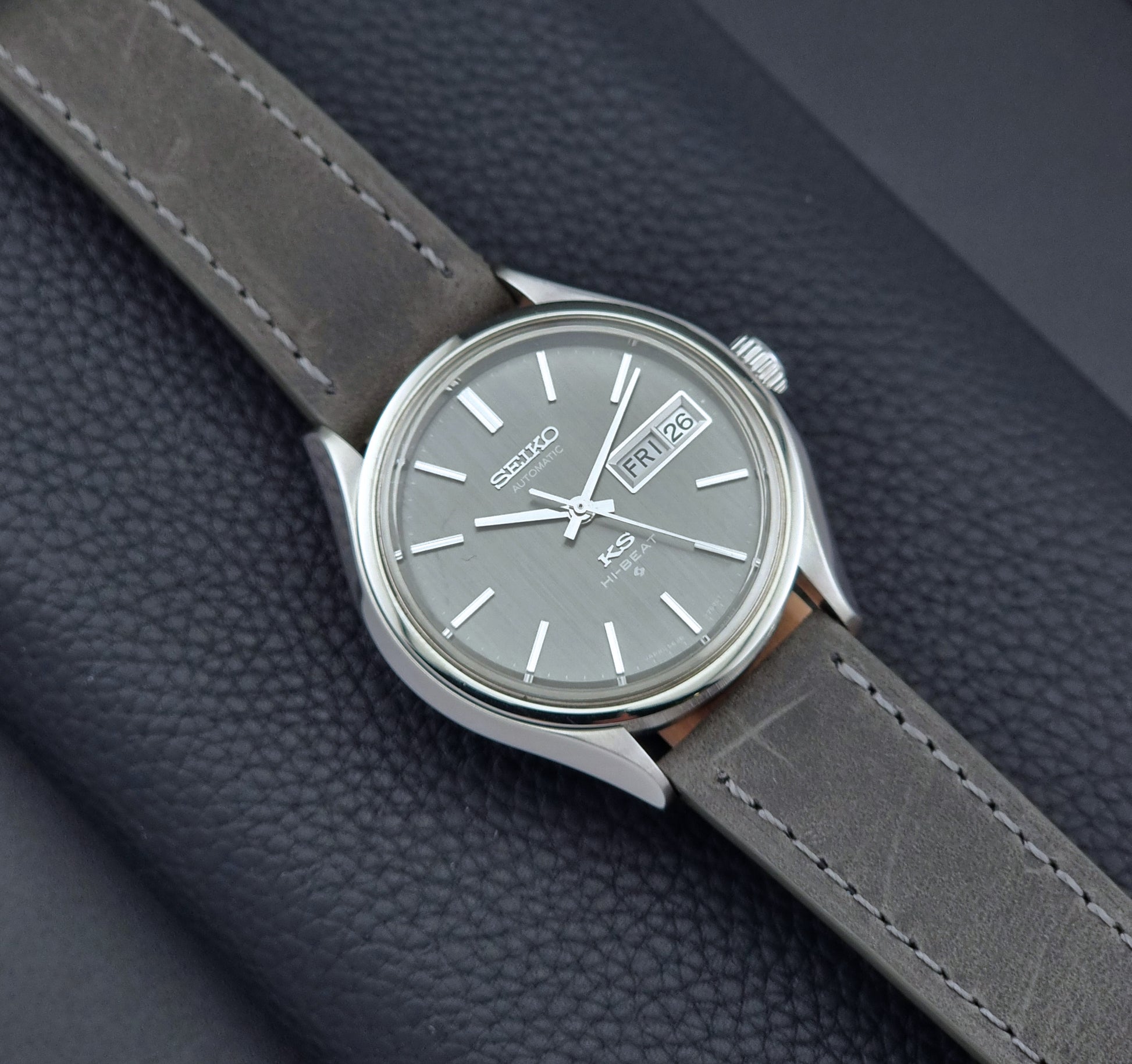 Vintage King Seiko watch with gray strap on a dark textured background