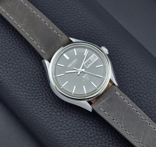 Vintage King Seiko watch with gray strap on a dark textured background