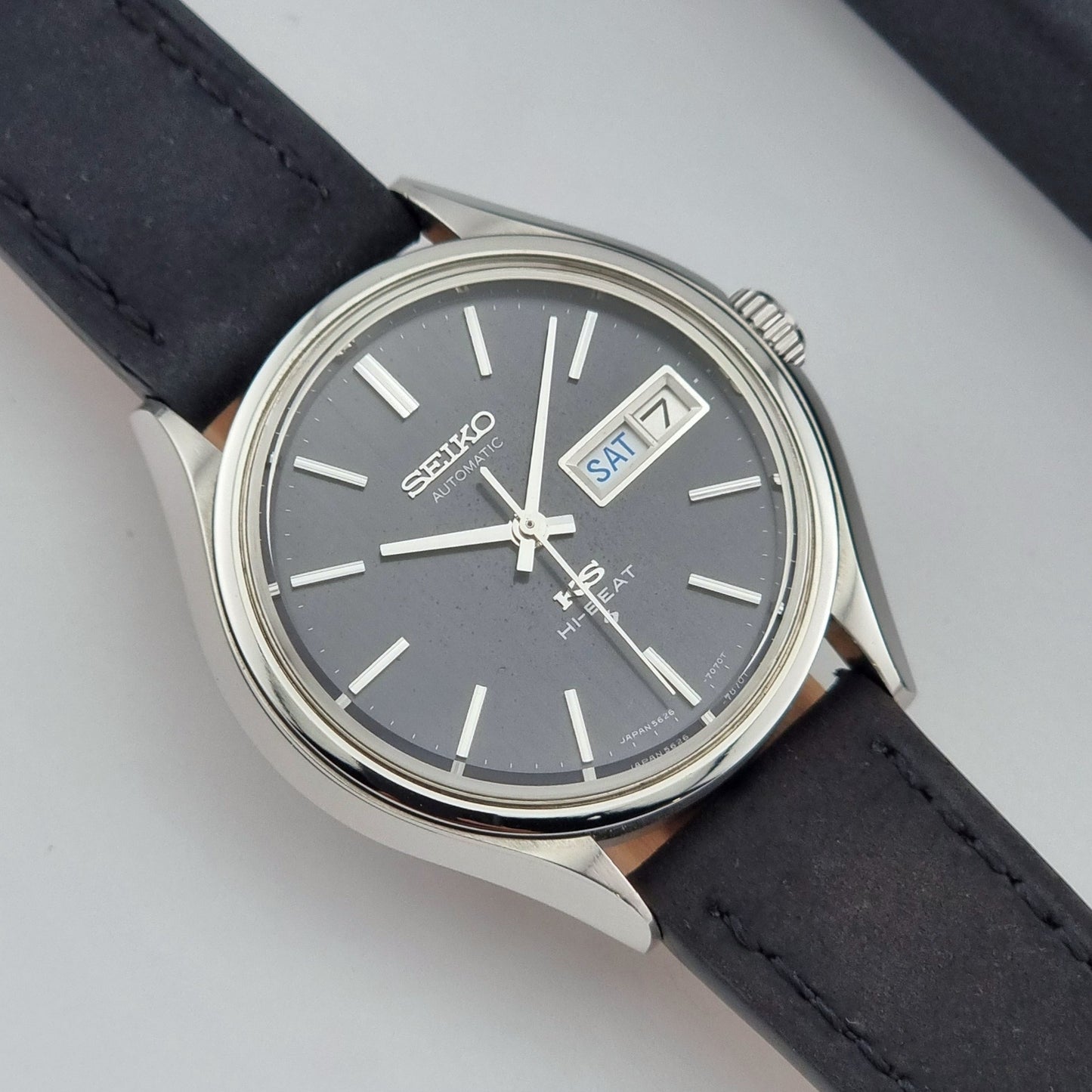 Vintage King Seiko Wristwatch 5626-7120 with black leather strap on a dark surface close front view
