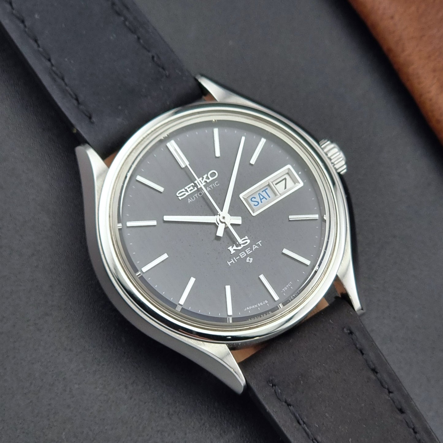 Vintage King Seiko Wristwatch 5626-7120 with black leather strap on a dark surface close up front view