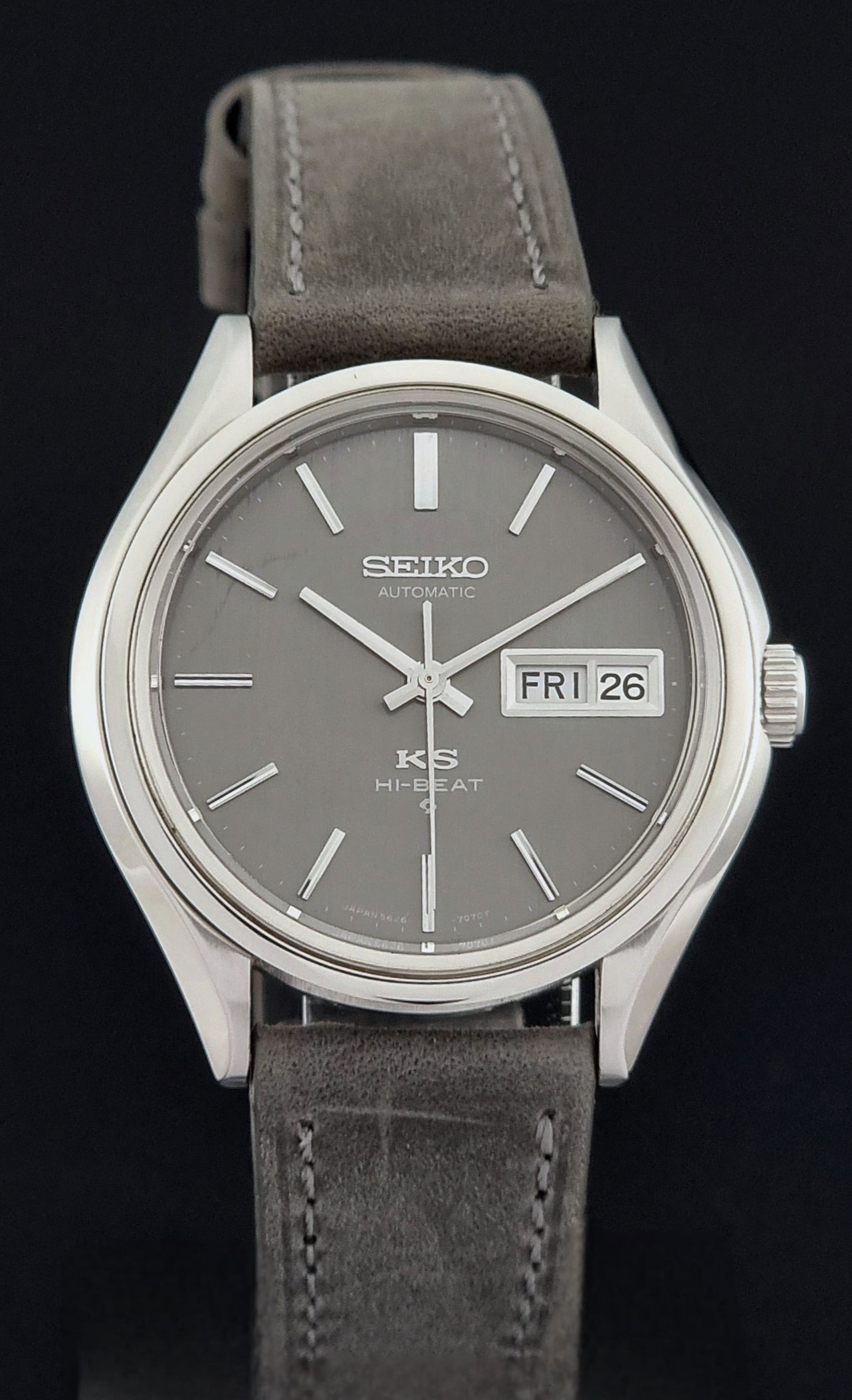 Vintage King Seiko watch with gray dial and leather strap on a black background