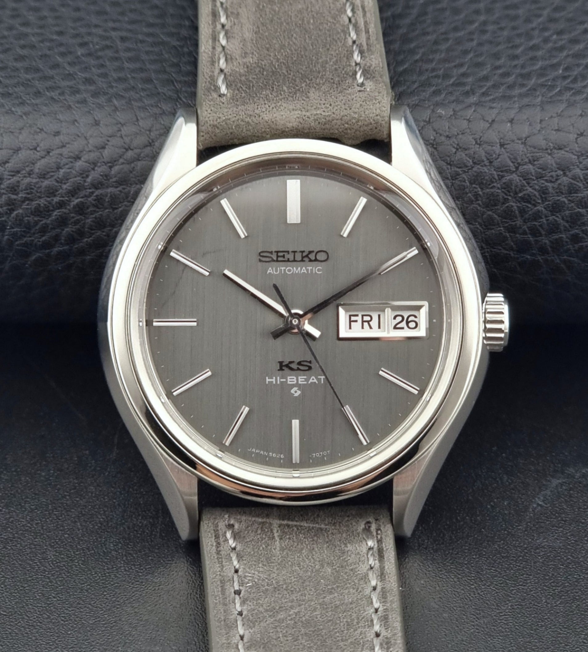 Vintage King Seiko watch with gray leather strap on a dark textured background