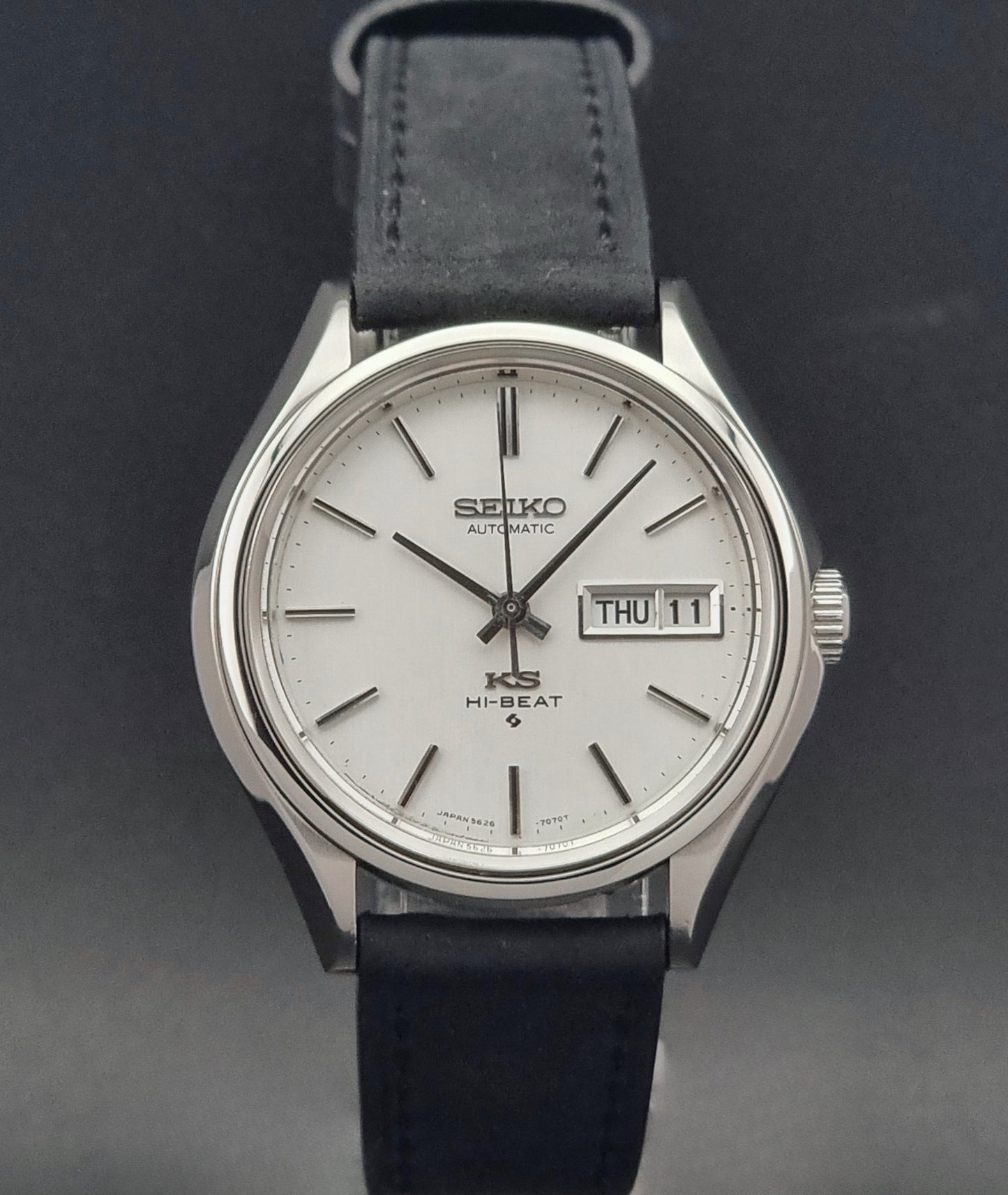 Vintage King Seiko Wristwatch Hi-beat 5626-7120 with a black strap on a dark background front