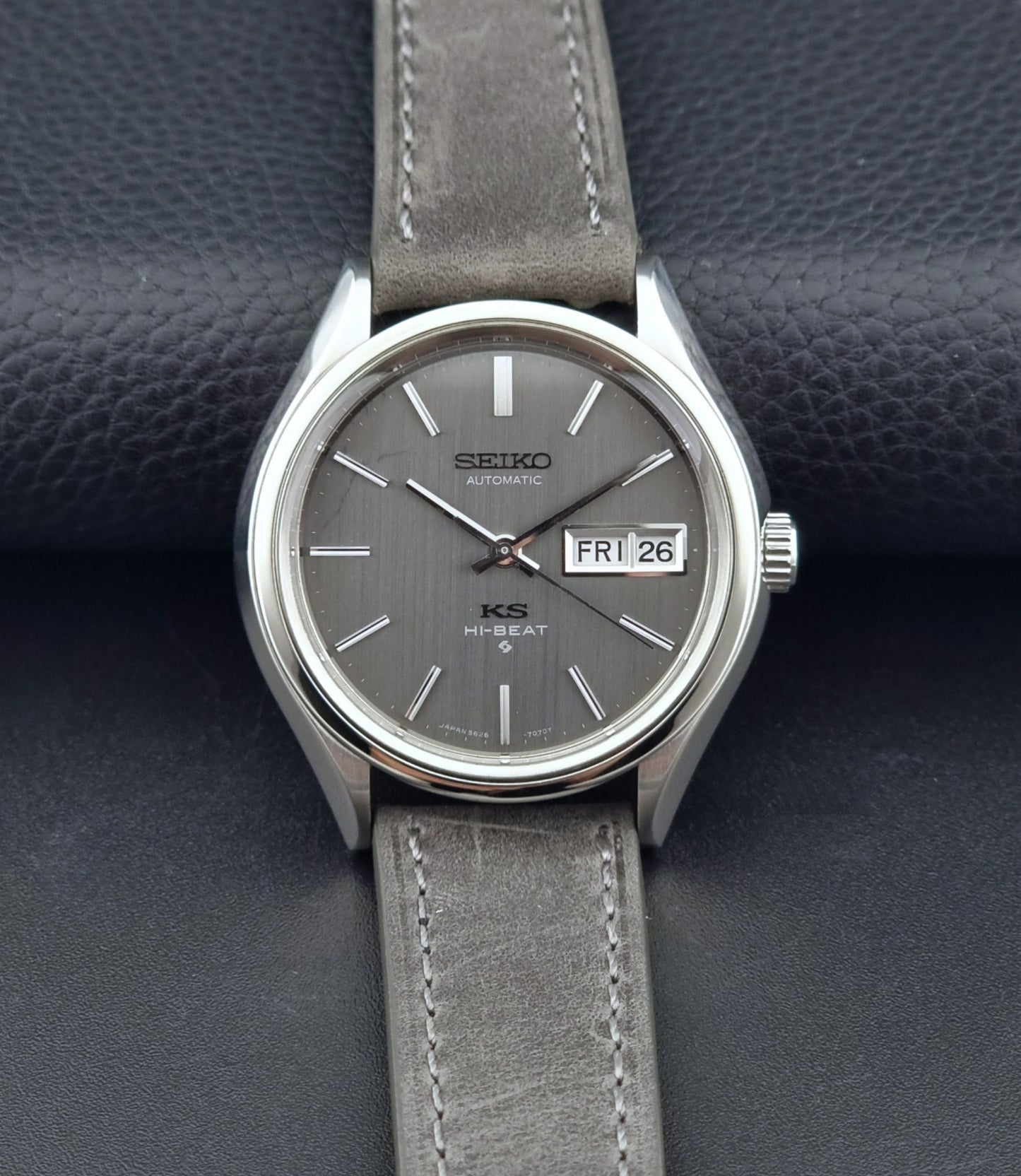 Vintage King Seiko watch with gray strap on a dark textured background