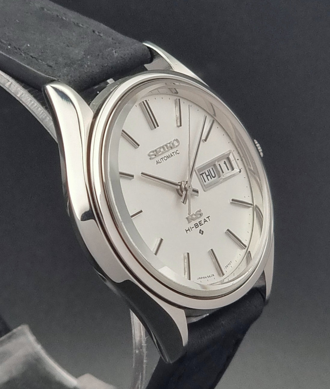 Vintage King Seiko Wristwatch Hi-beat 5626-7120 with a black strap on a dark background profile view