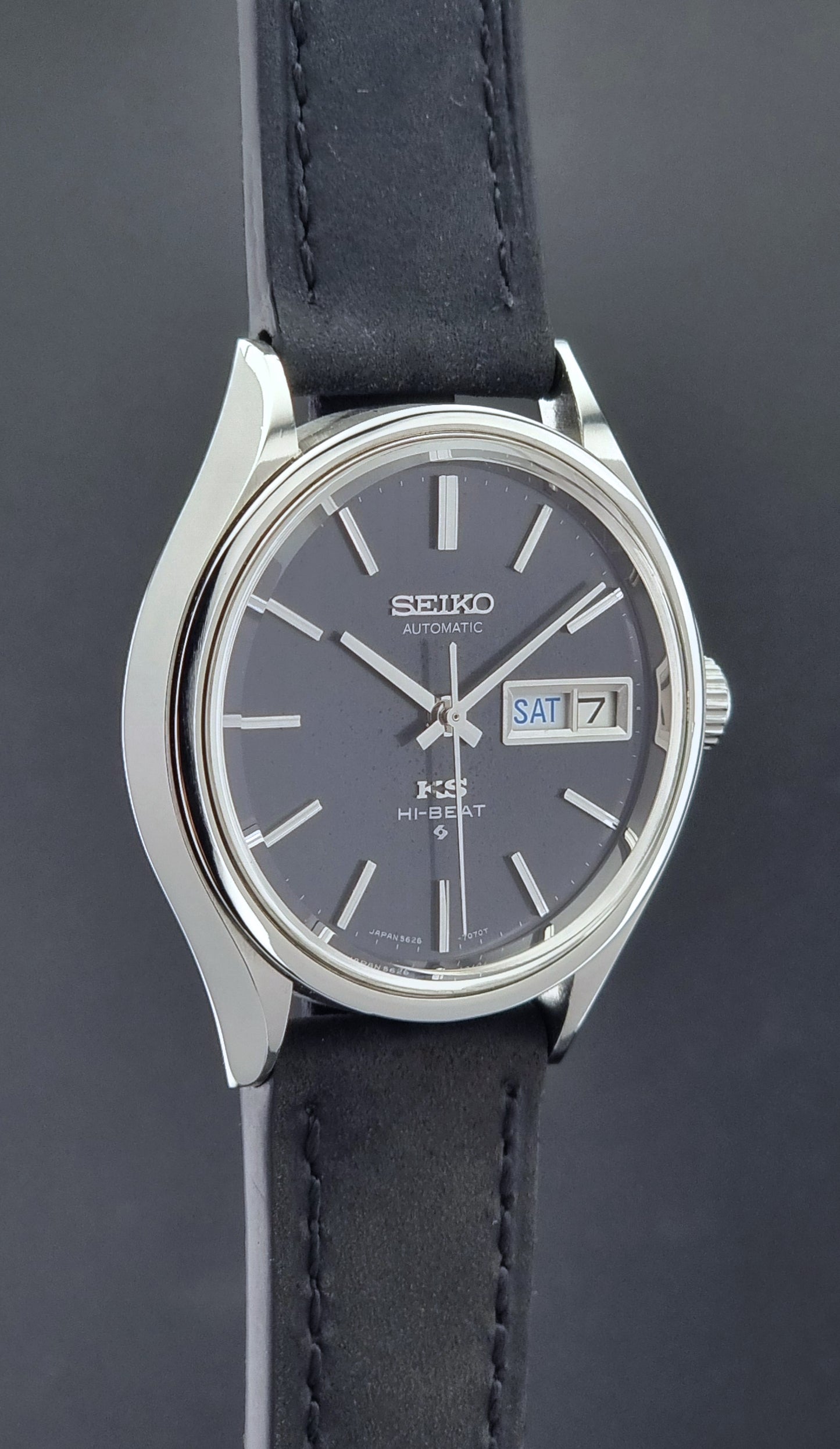 Vintage King Seiko Wristwatch 5626-7120 with black leather strap on a dark surface side profile view