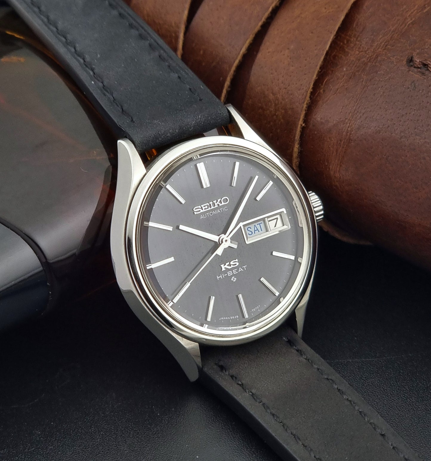 Vintage King Seiko Wristwatch 5626-7120 with black leather strap on a dark surface side view