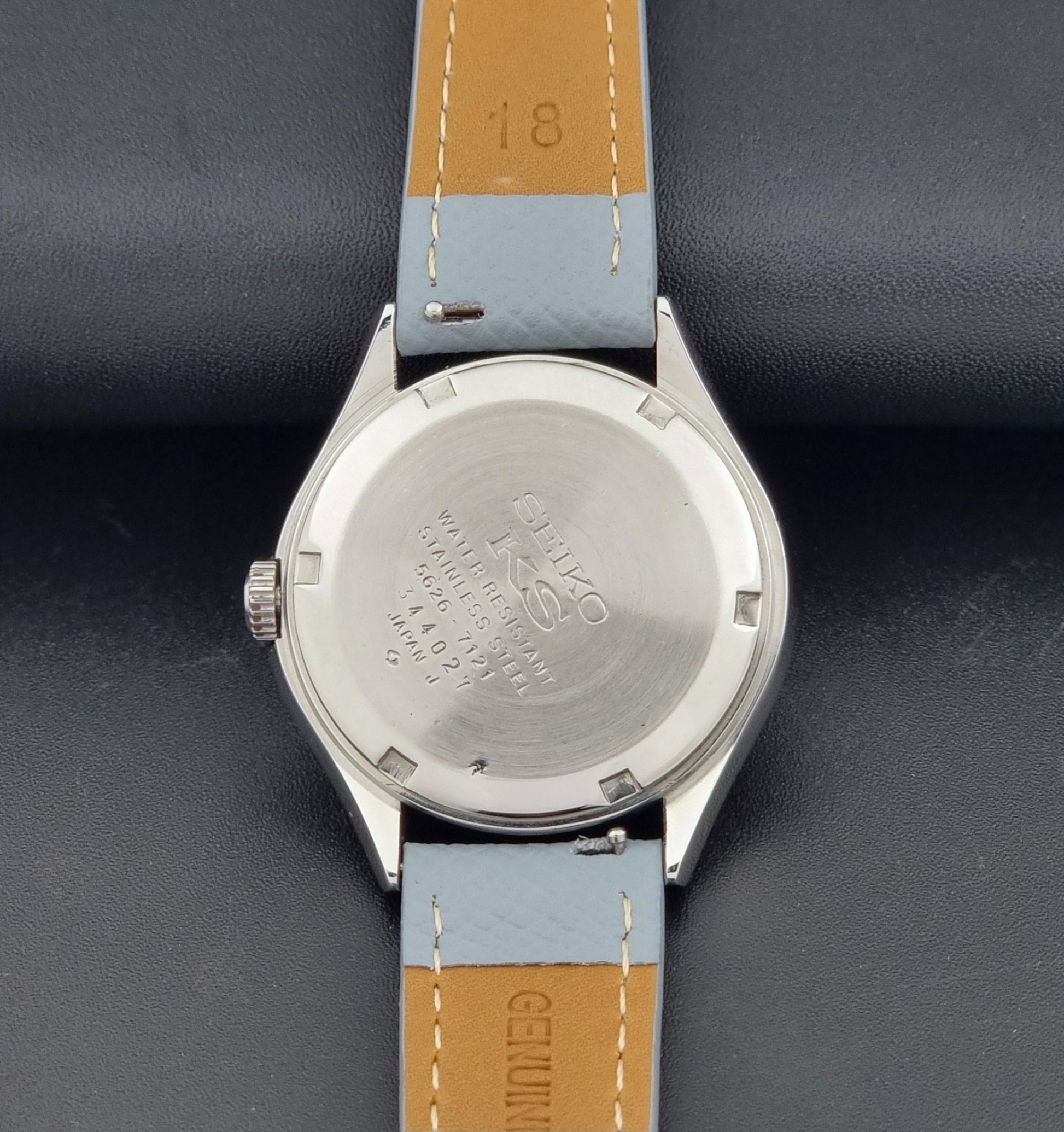 Vintage King Seiko Wristwatch 5626-7121 with a grey strap on a dark background case back view