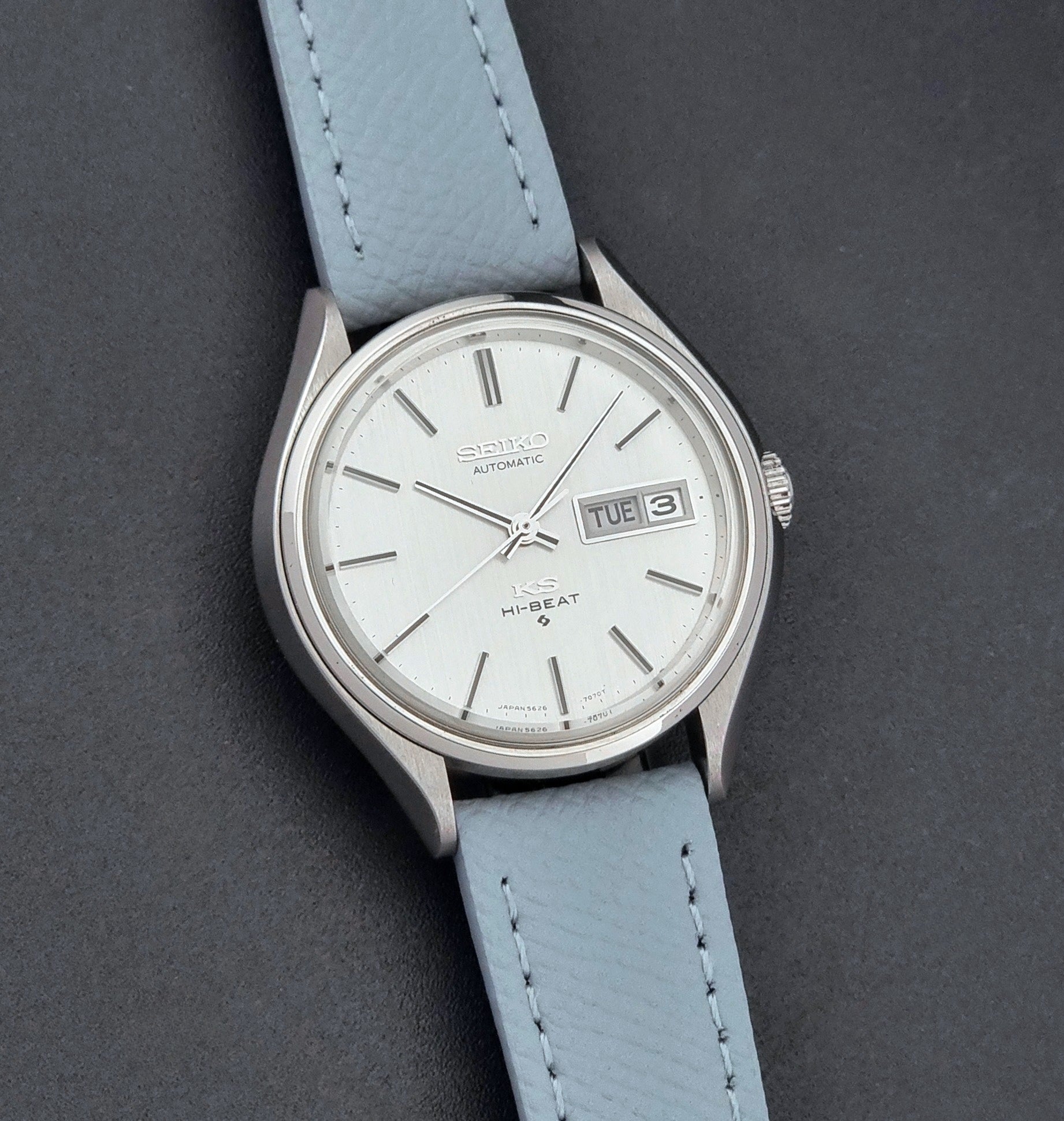 Vintage King Seiko Wristwatch 5626-7121 with a grey strap on a dark background front view
