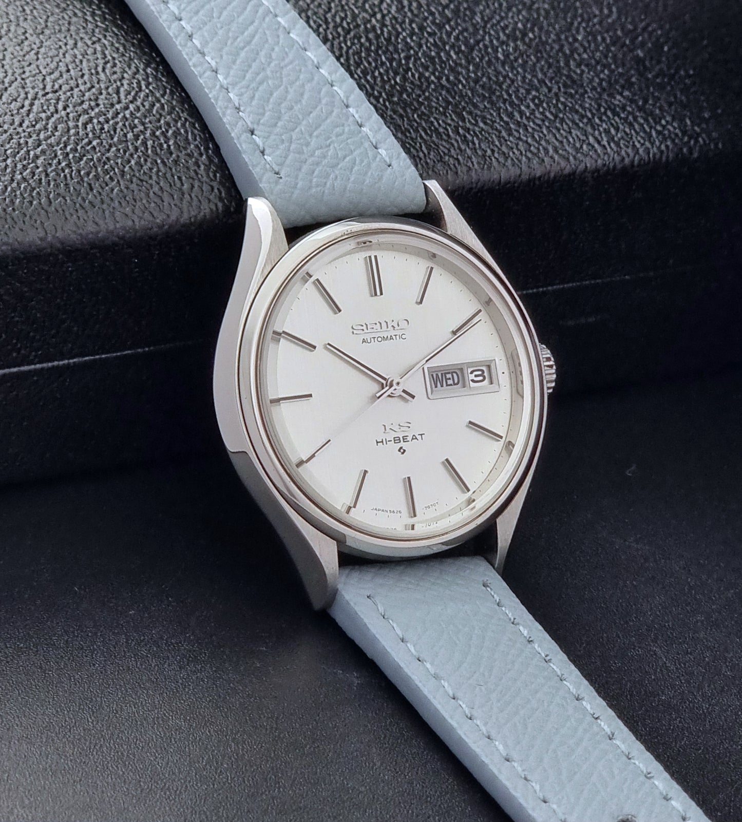 Vintage King Seiko Wristwatch 5626-7121 with a grey strap on a dark background side view