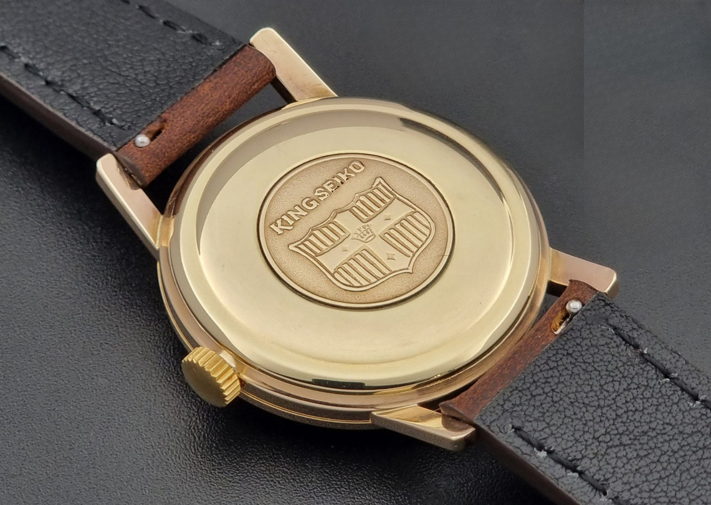 Vintage King Seiko Watch J14102 with brown leather strap on a wooden surface case back