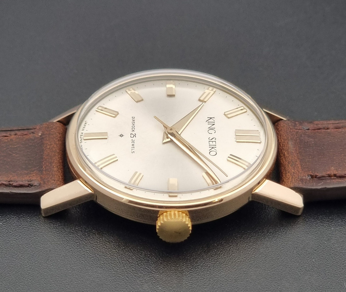 Vintage King Seiko Watch J14102 with brown leather strap on a wooden surface replacement crown view