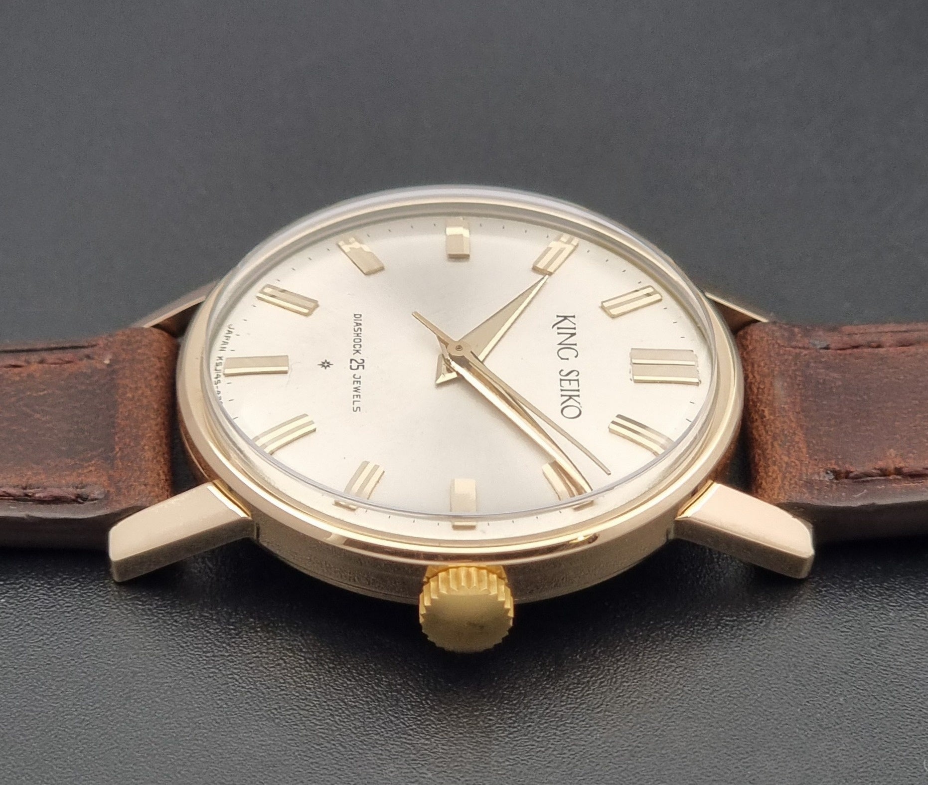Vintage King Seiko Watch J14102 with brown leather strap on a wooden surface replacement crown view