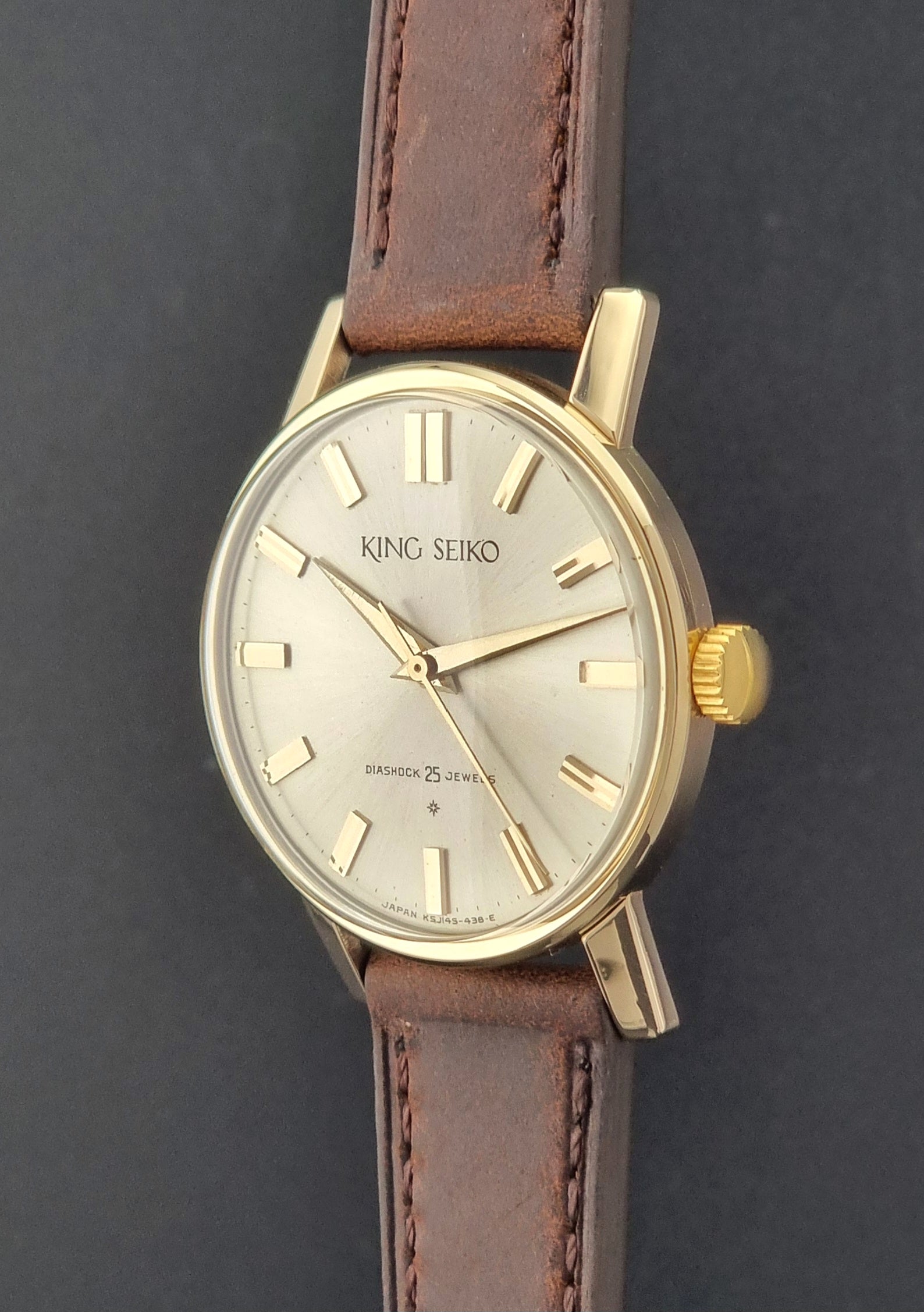Vintage King Seiko Watch J14102 with brown leather strap on a wooden surface crown profile