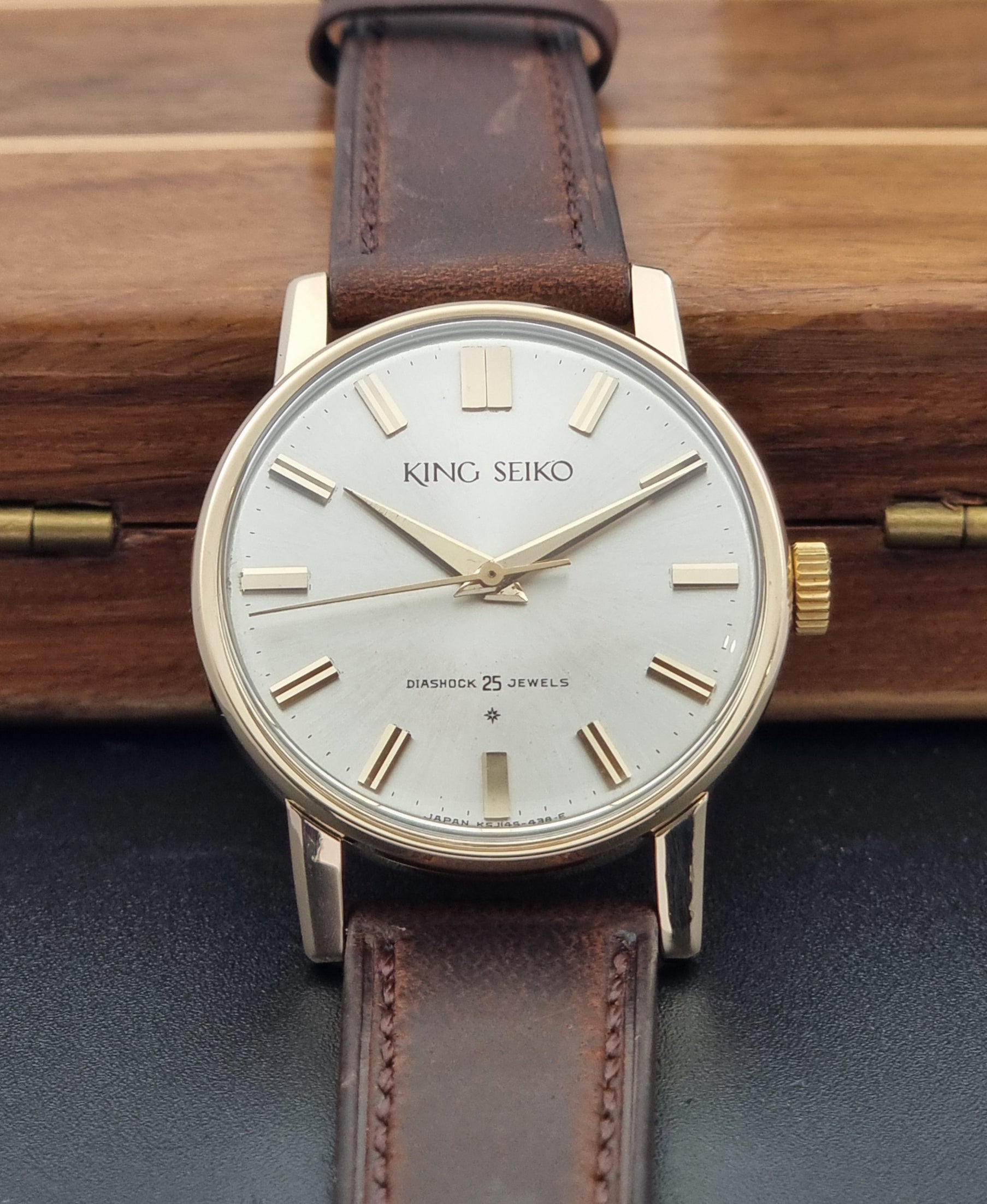 Vintage King Seiko Watch J14102 with brown leather strap on a wooden surface close up