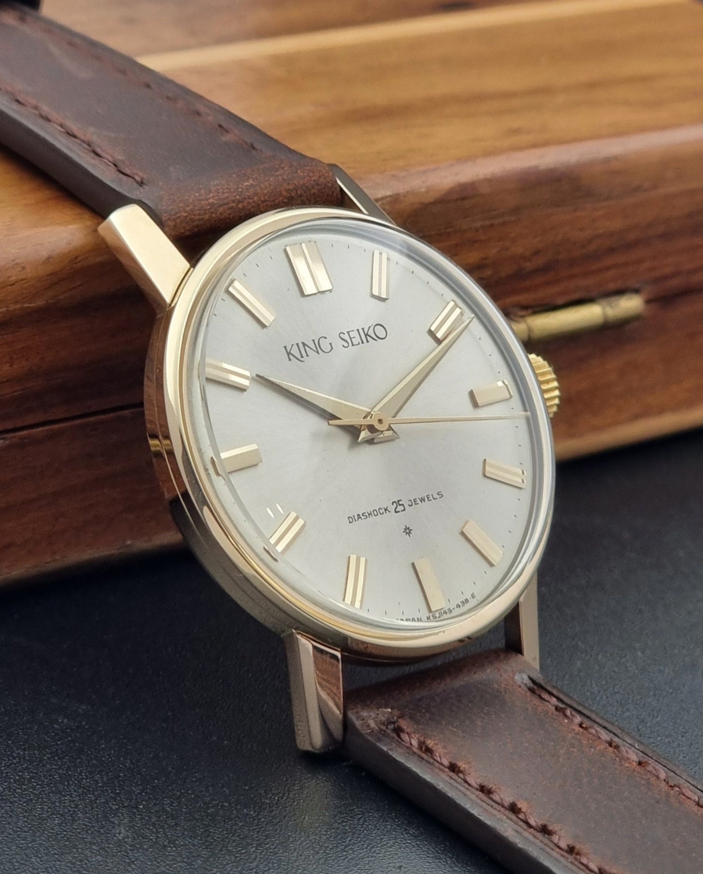 Vintage King Seiko Watch J14102 with brown leather strap on a wooden surface side view