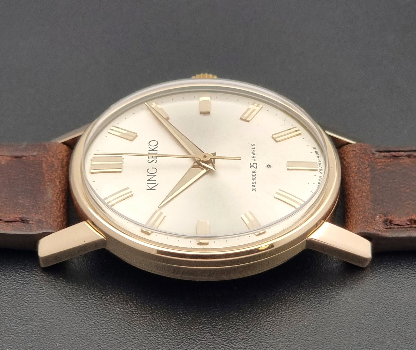 Vintage King Seiko Watch J14102 with brown leather strap on a wooden surface side view