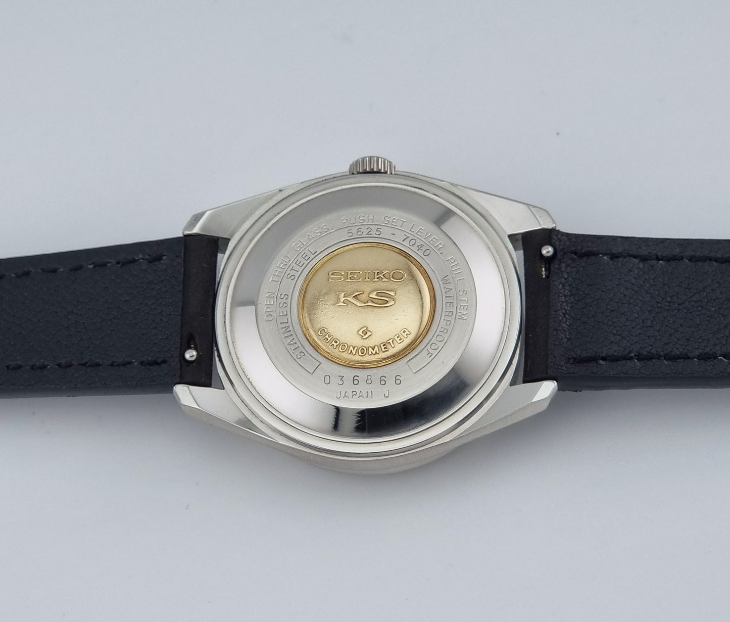 Vintage King Seiko 5625-7040 watch watch with black leather strap on a light gray background case back view