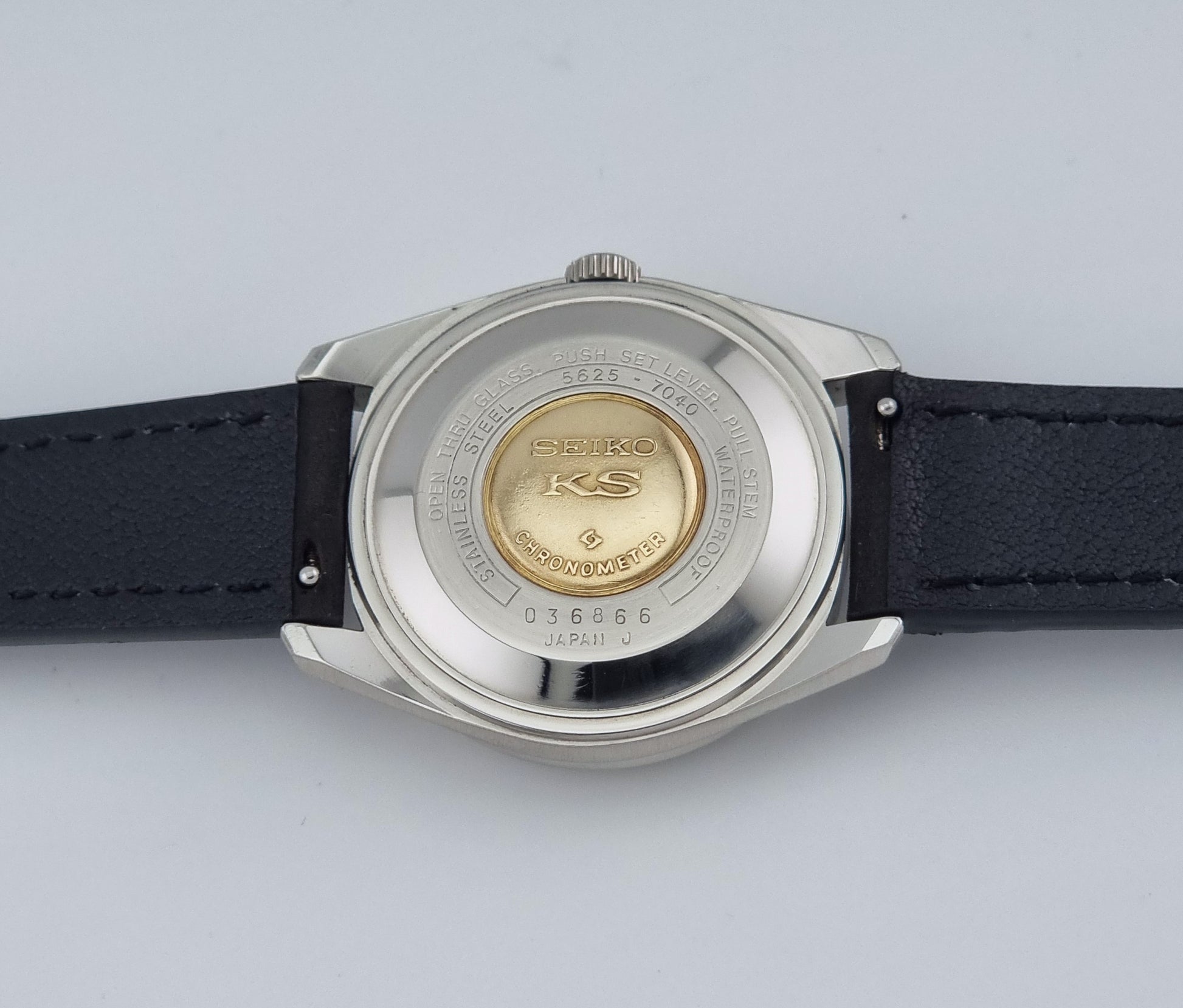 Vintage King Seiko 5625-7040 watch watch with black leather strap on a light gray background case back view