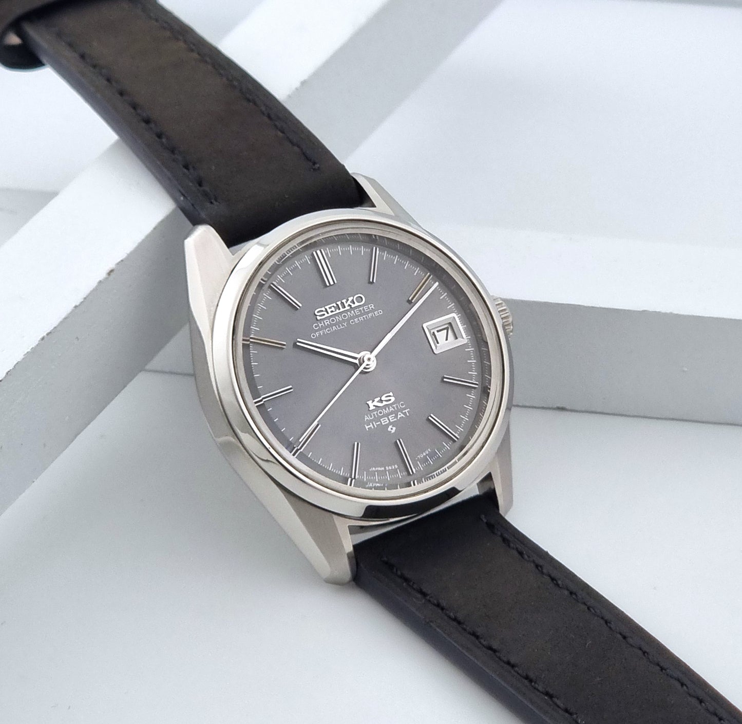 Vintage King Seiko 5625-7040 watch watch with black leather strap on a light gray background side view