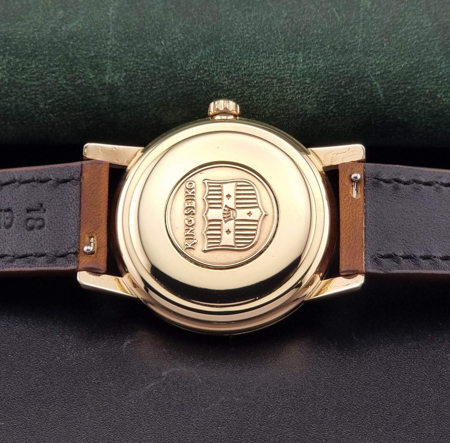 Vintage King Seiko J14102E Watch with brown leather strap on a dark gray background case back view