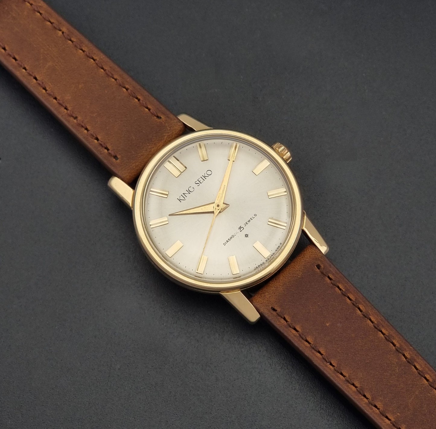 Vintage King Seiko J14102E Watch with brown leather strap on a dark gray background dial
