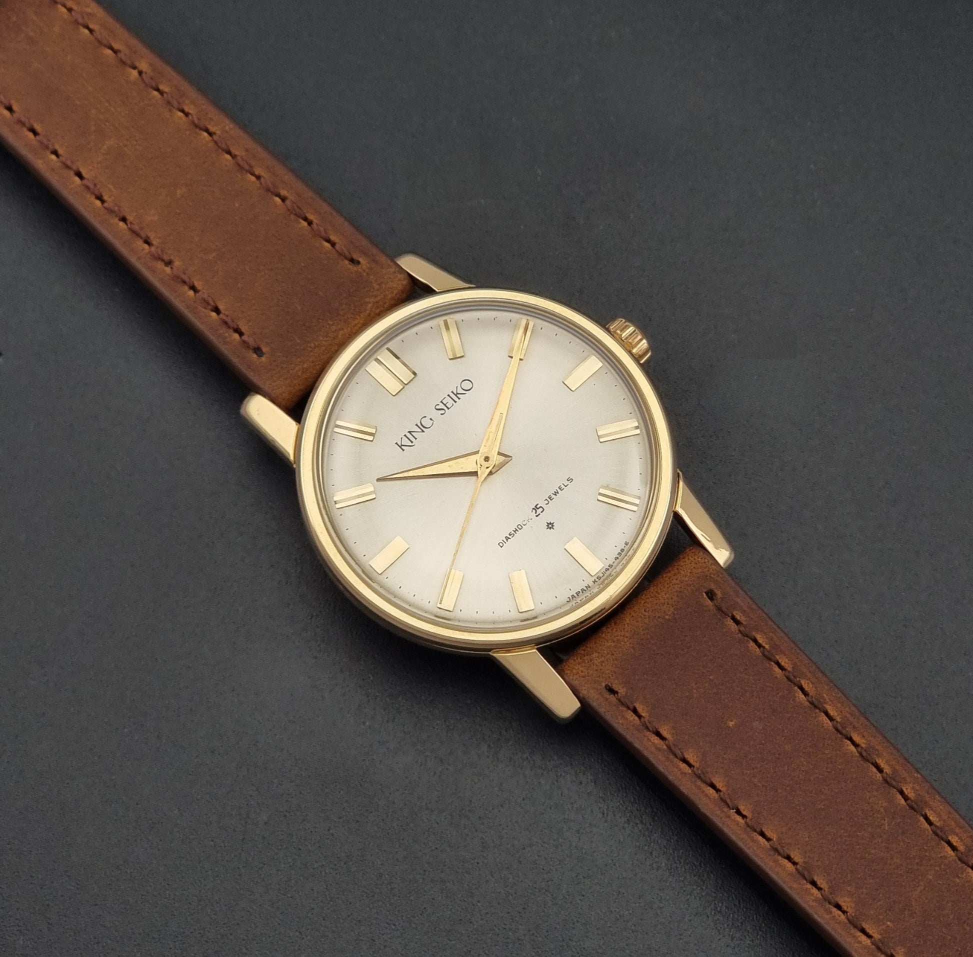 Vintage King Seiko J14102E Watch with brown leather strap on a dark gray background dial