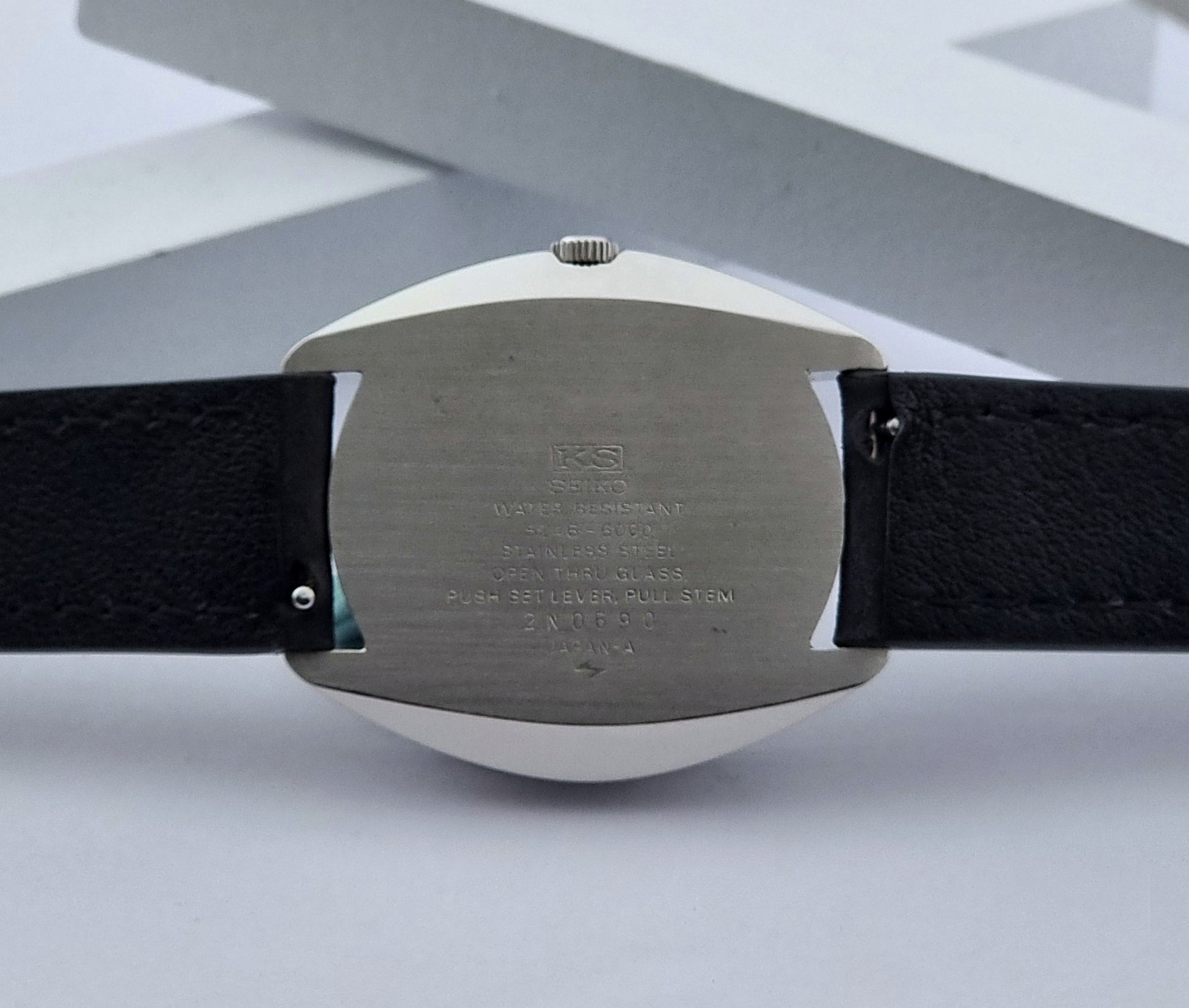 Vintage King Seiko Watch Special 5246-6000 with black leather strap on a light gray background case abck view
