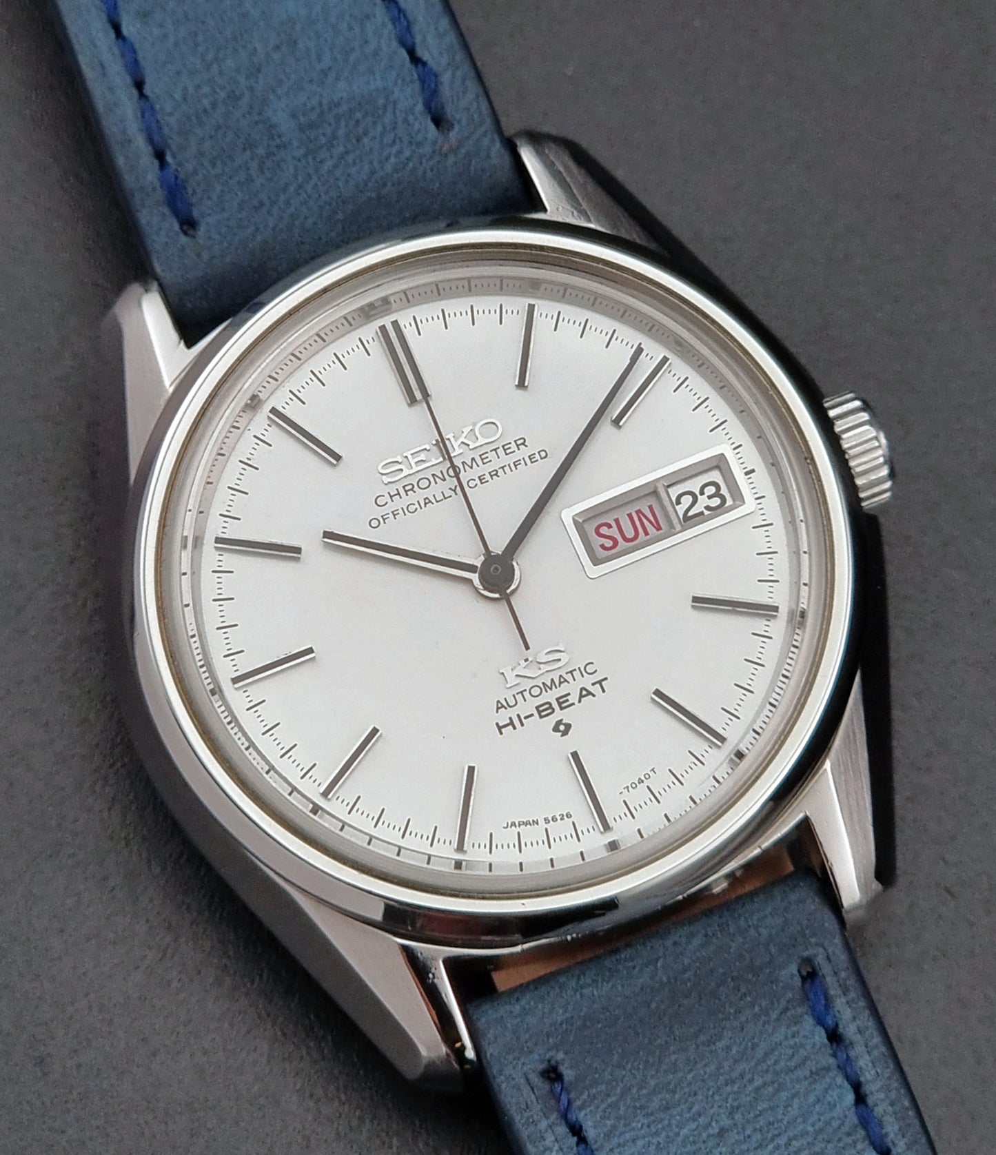 Seiko watch with blue strap on a gray background