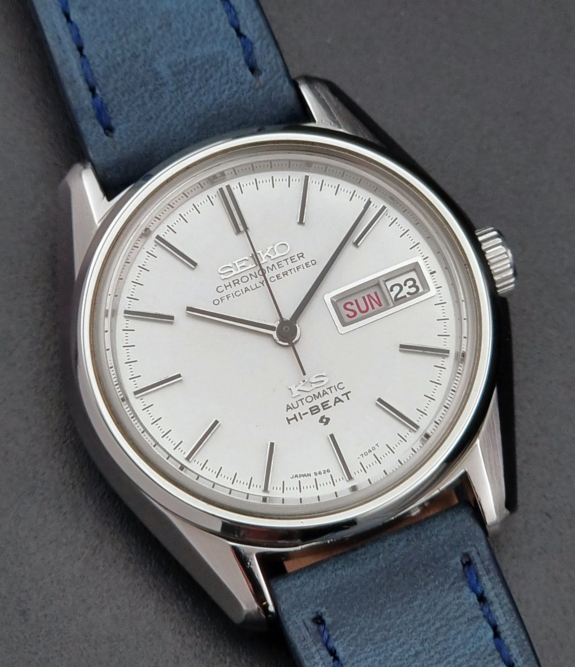 Seiko watch with blue strap on a gray background