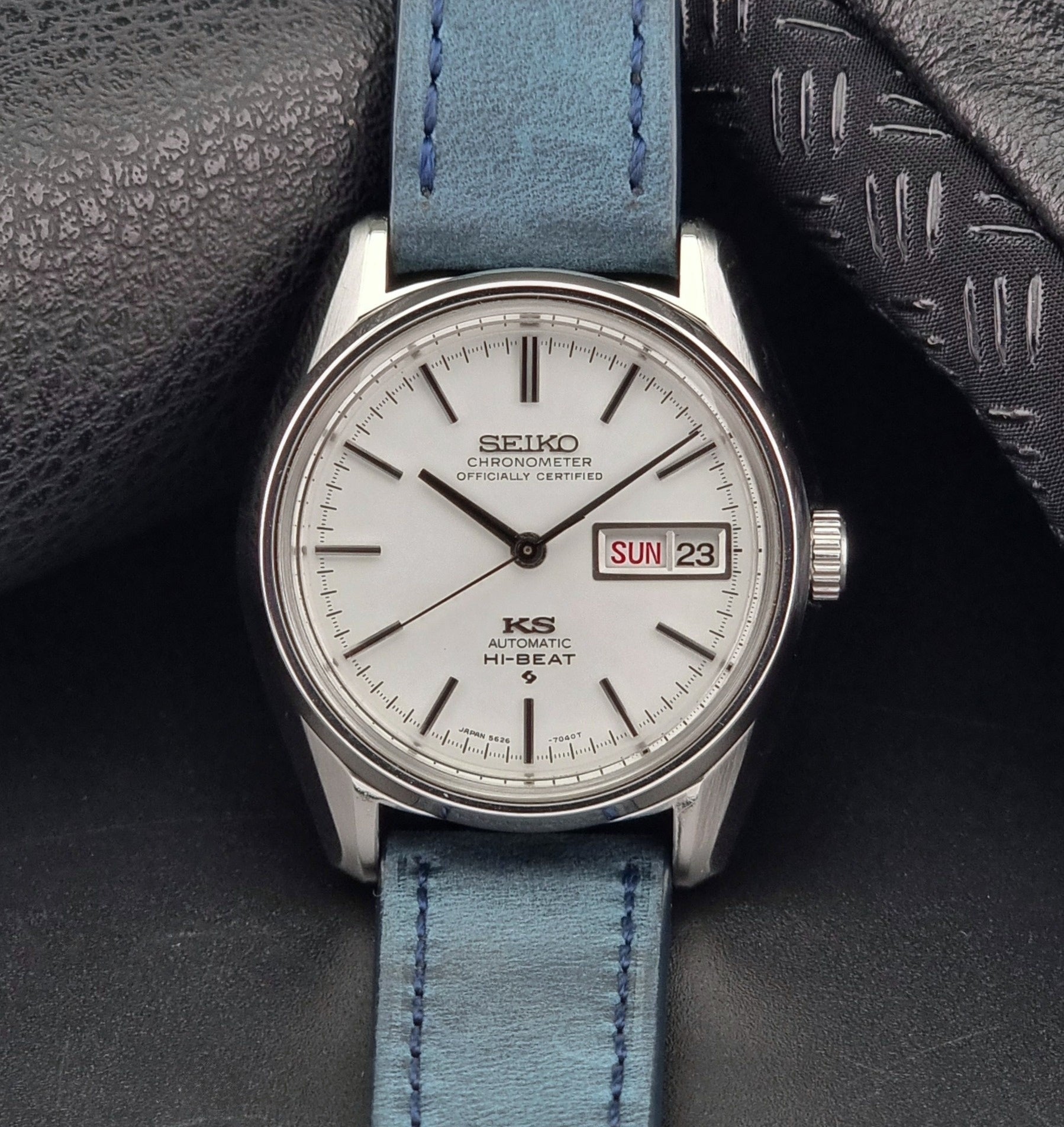 King Seiko watch with blue strap on a textured surface