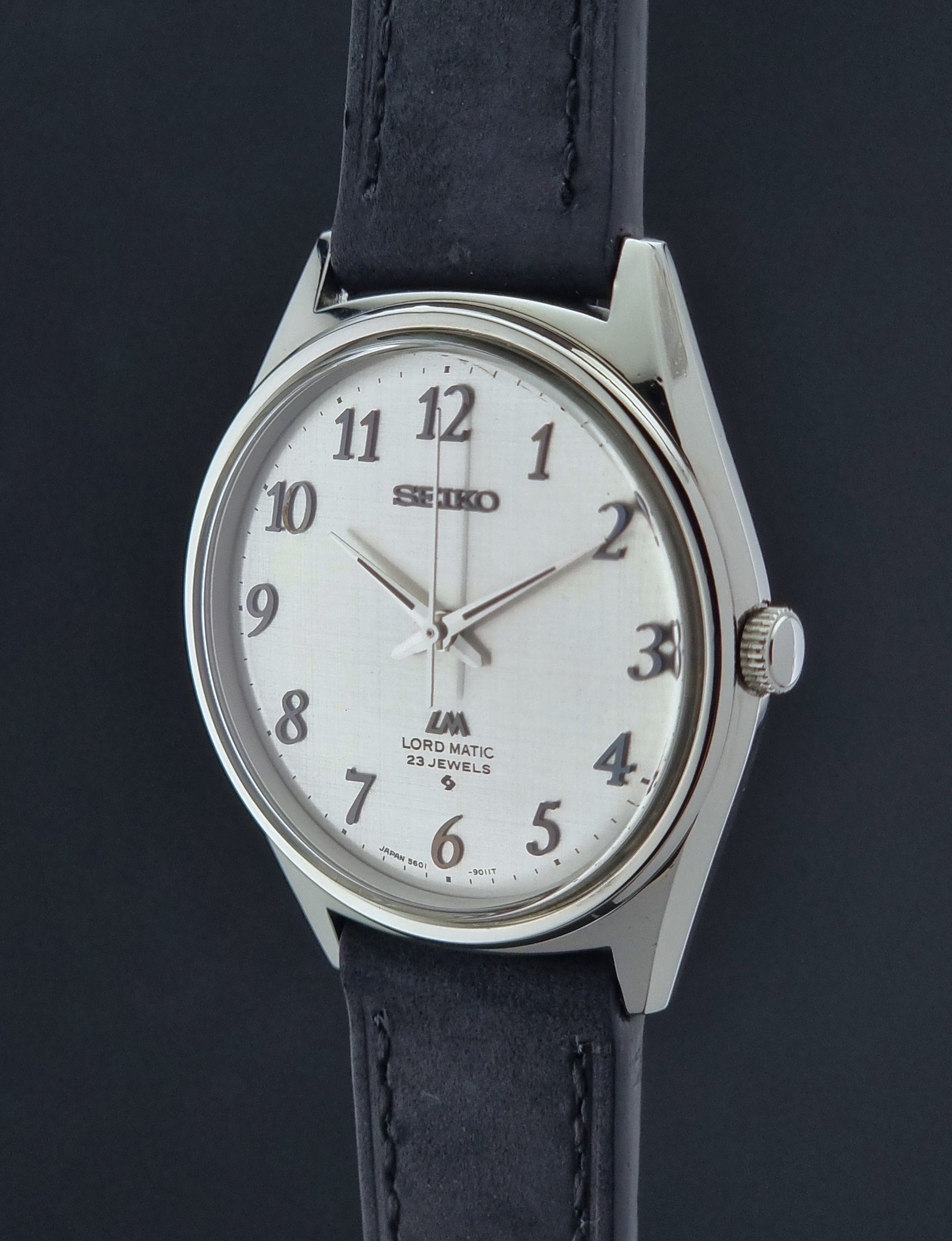 Seiko watch with black leather strap on a dark background