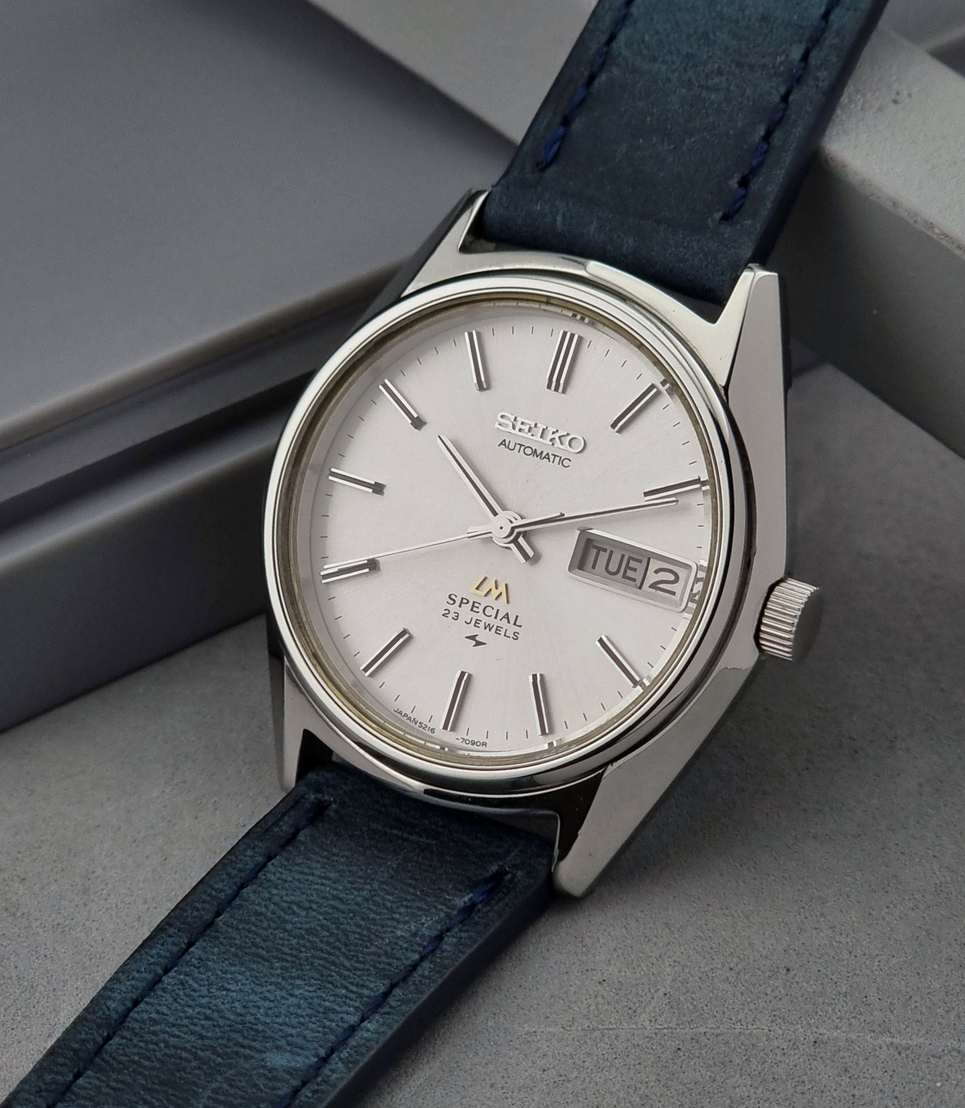 Seiko Wristwatch LordMatic Special 5216-7080 Vintage 1974 with blue leather strap on a gray surface