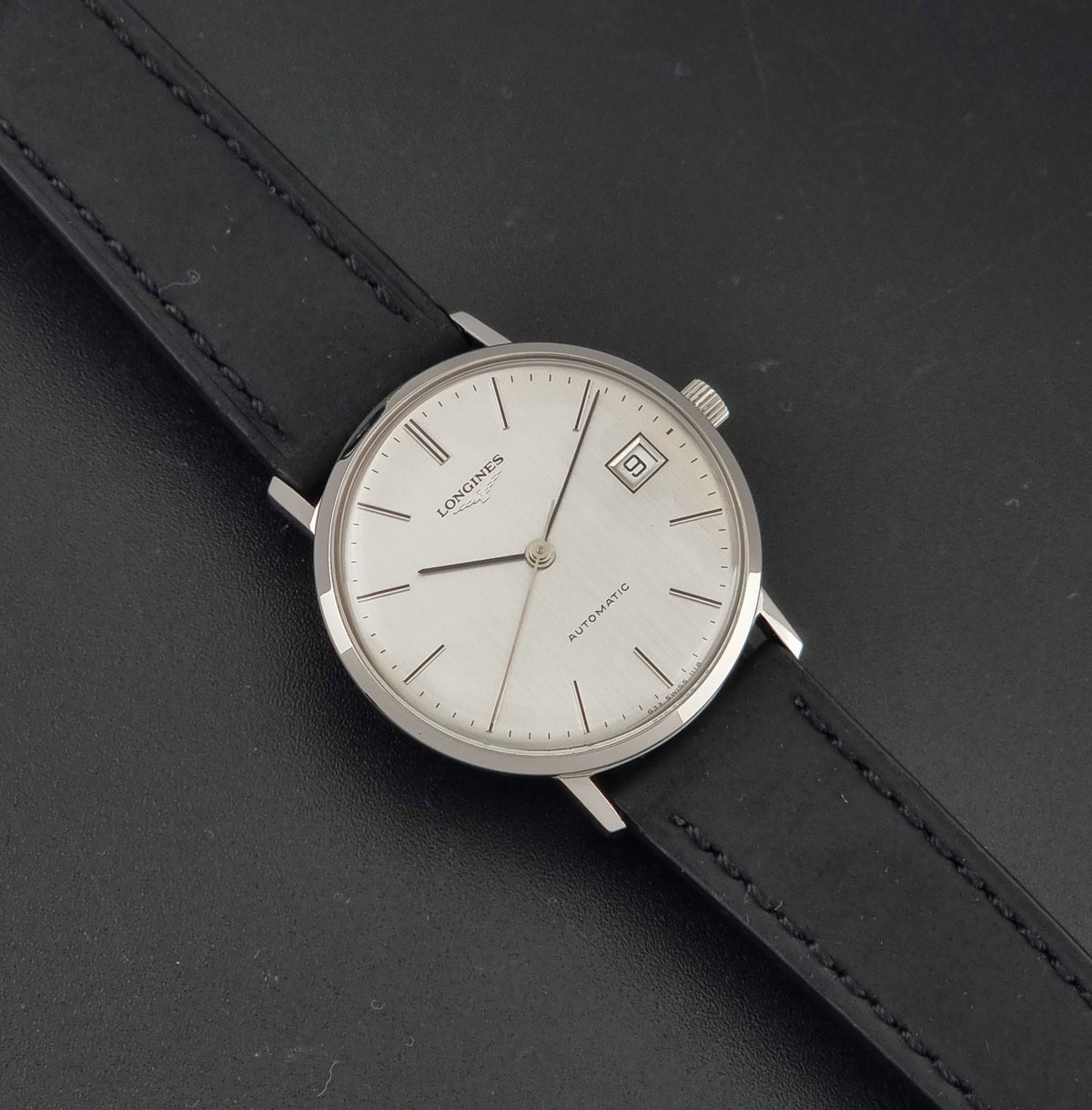 1977 vintage Longines 1118 automatic date watch, front view featuring the vertically brushed silver dial