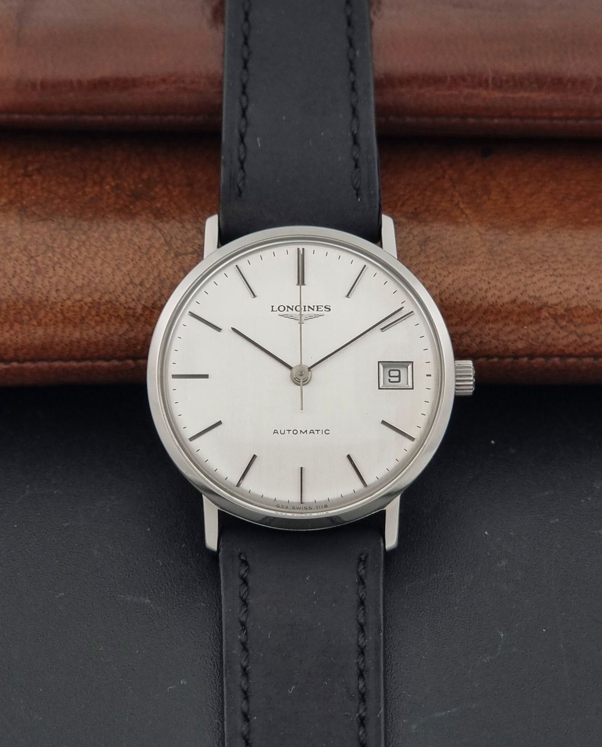 1977 vintage Longines 1118 automatic date watch, alternate front view showing the vertically brushed silver dial and case