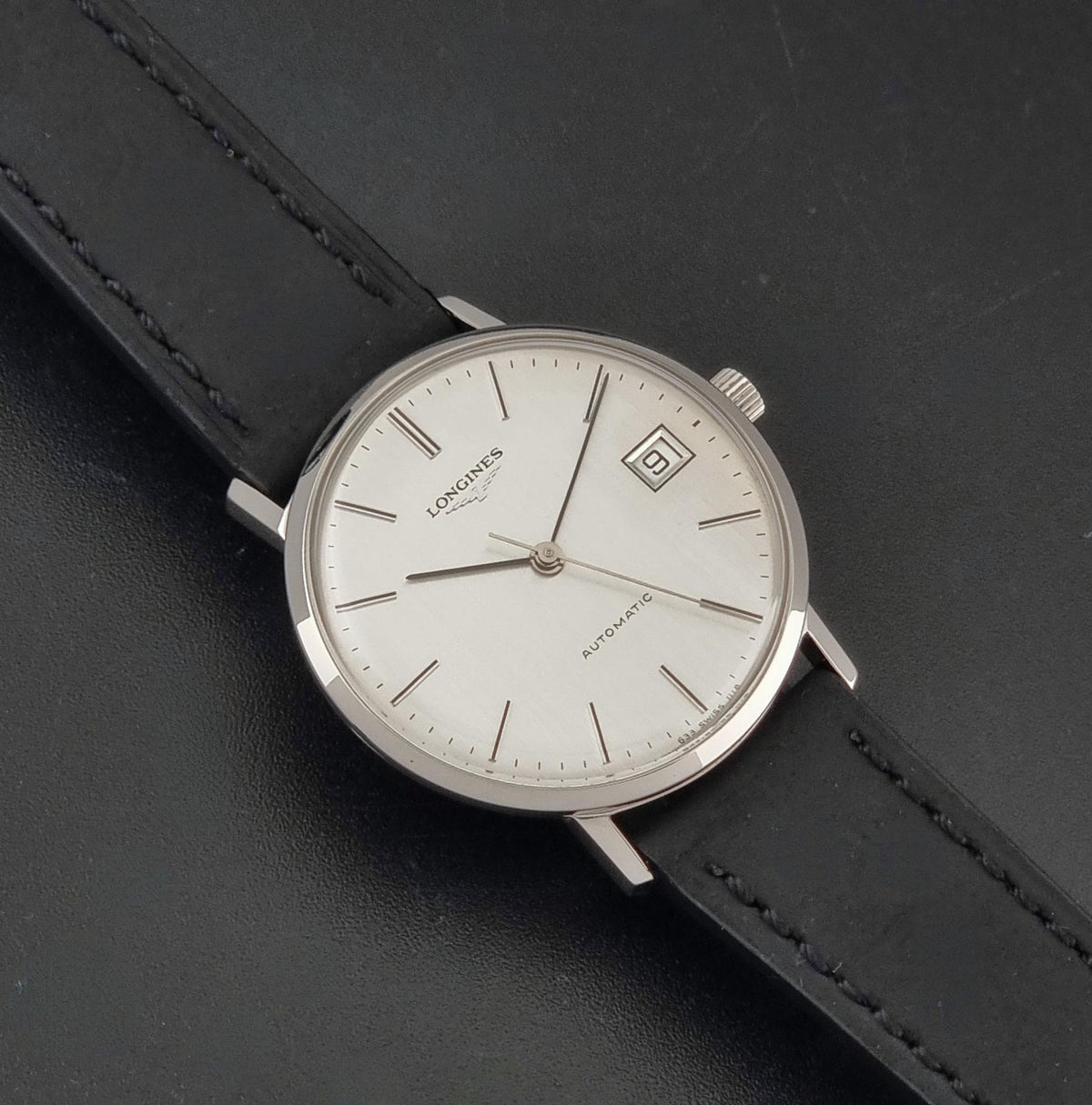 1977 vintage Longines 1118 automatic date watch, front view highlighting the vertically brushed silver dial