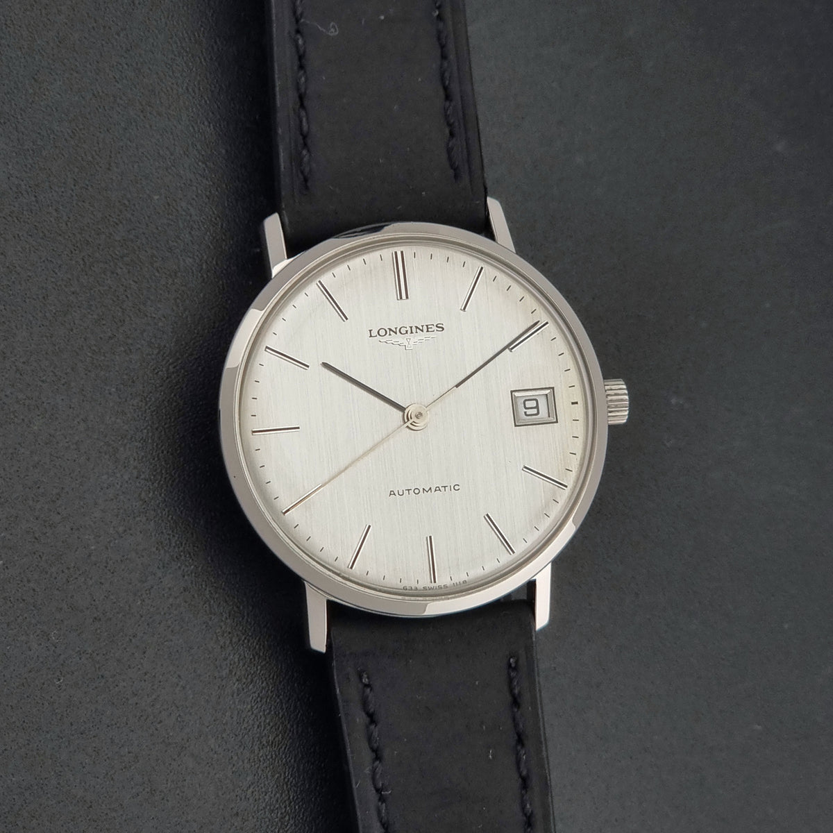 1977 vintage Longines 1118 automatic date watch, additional face-on view of the vertically brushed silver dial and hands