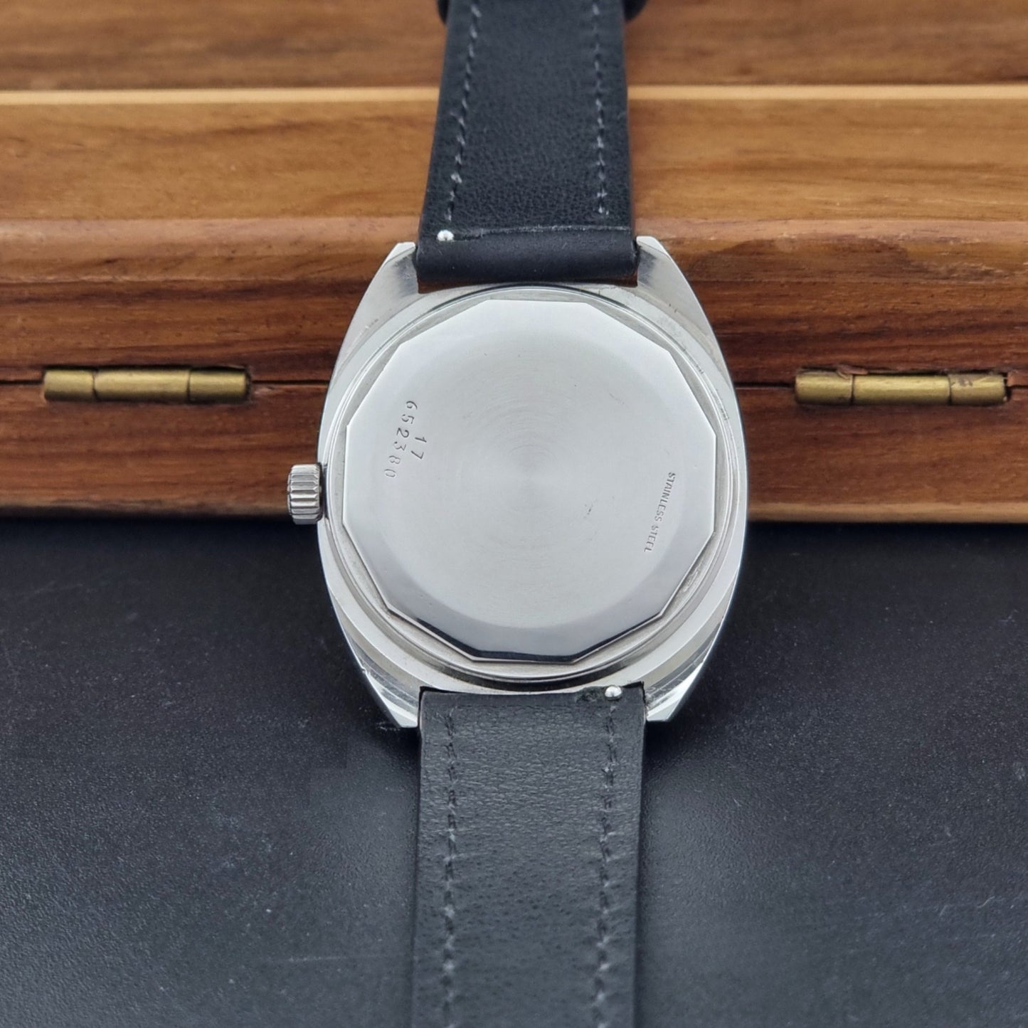 Vintage Longines 1584-1 watch with a black strap on a dark background case back view