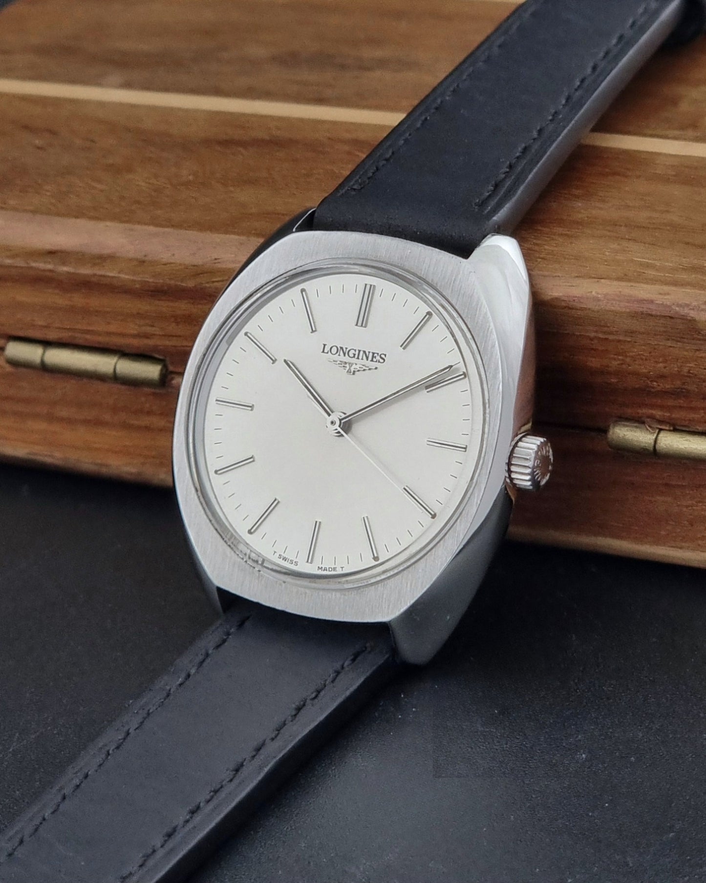 Vintage Longines 1584-1 watch with a black strap on a dark background side view