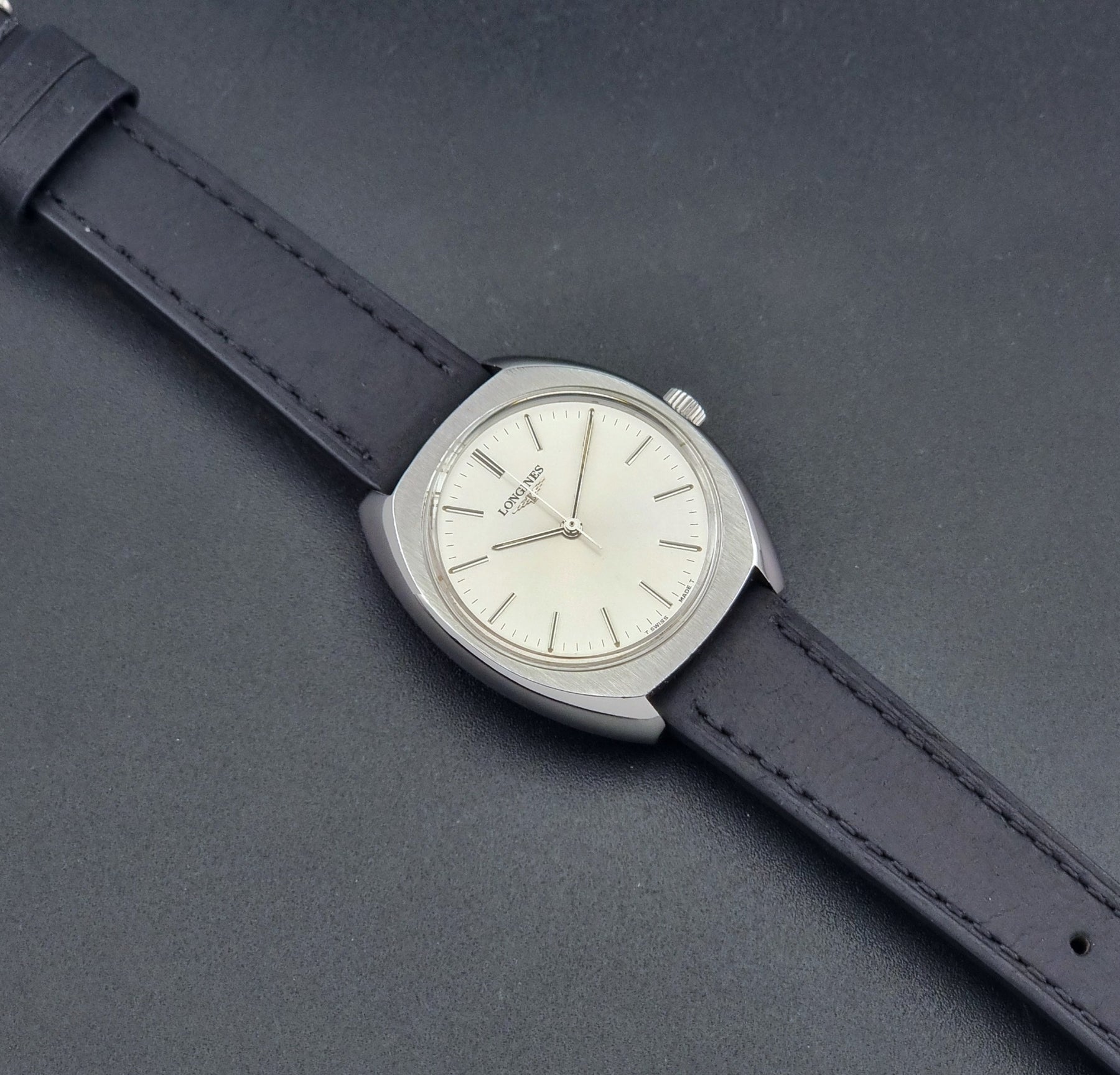 Vintage Longines 1584-1 watch with a black strap on a dark background dial