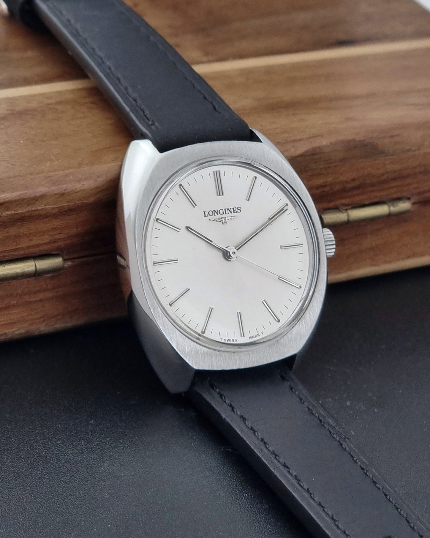 Vintage Longines 1584-1 watch with a black strap on a dark background crown view