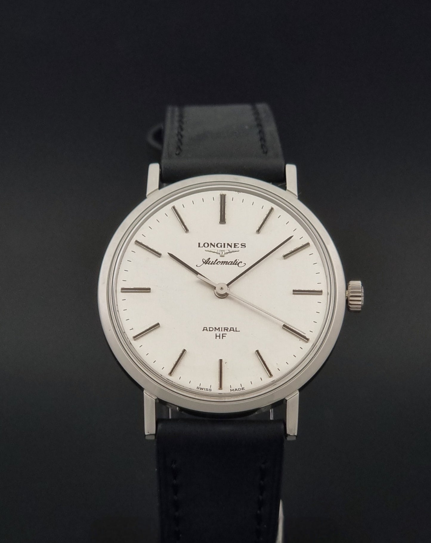 Vintage Longines Admiral Hi frequency Automatic Wristwatch 2305-1 with a black leather strap on a grey background close front view