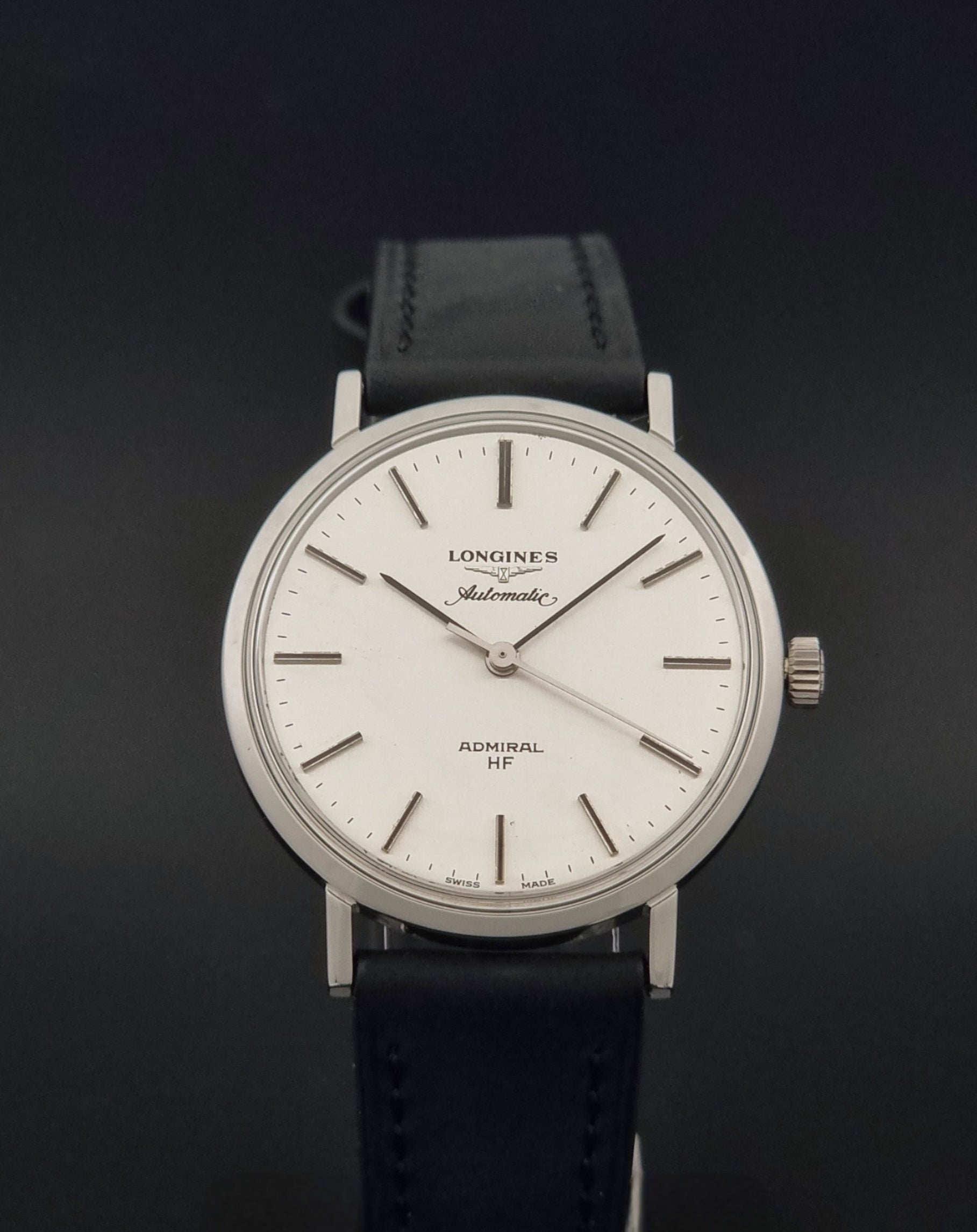 Vintage Longines Admiral Hi frequency Automatic Wristwatch 2305-1 with a black leather strap on a grey background close front view