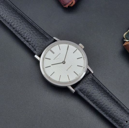 Vintage Longines Wristwatch 3029-2 with a black leather strap on a dark gray background dial