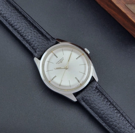 Vintage Longines Wristwatch 7624-1 with a black leather strap on a dark gray background dial